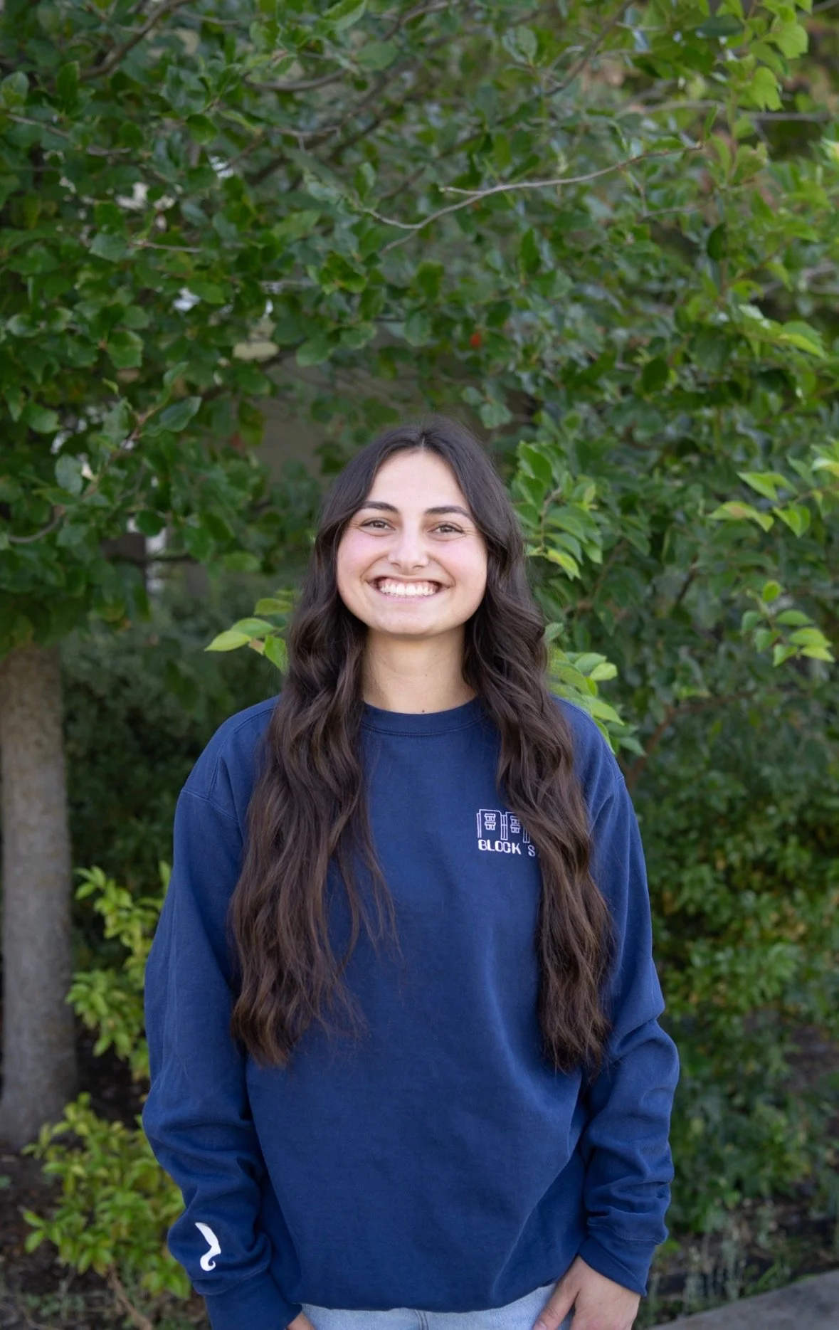 A young woman with long dark hair smiling at the camera.