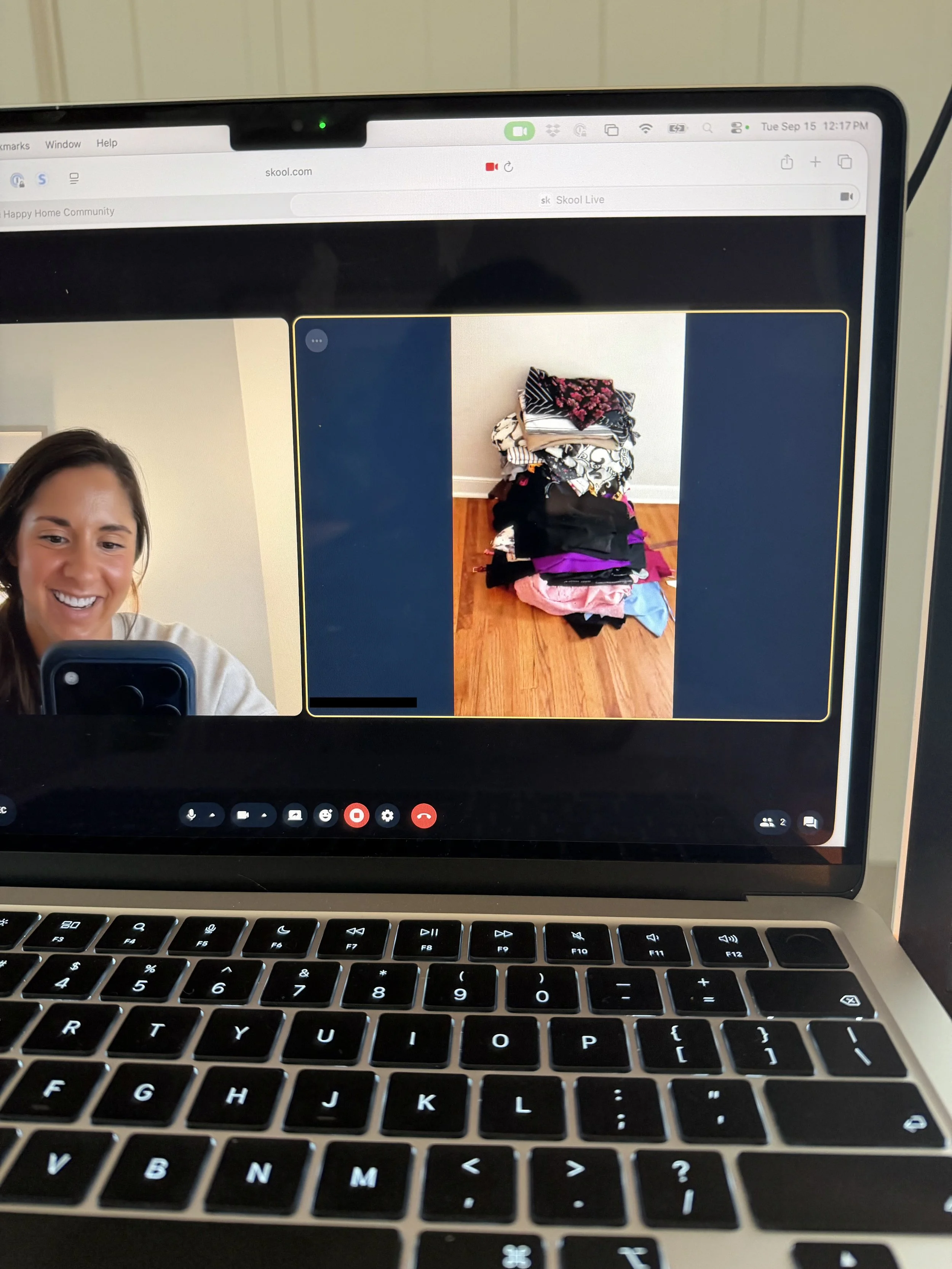 A screenshot of Melissa Welch working on a video call with a member of her online community for decluttering and organizing, and shows a large pile of clothes that are going to be donated and decluttered.
