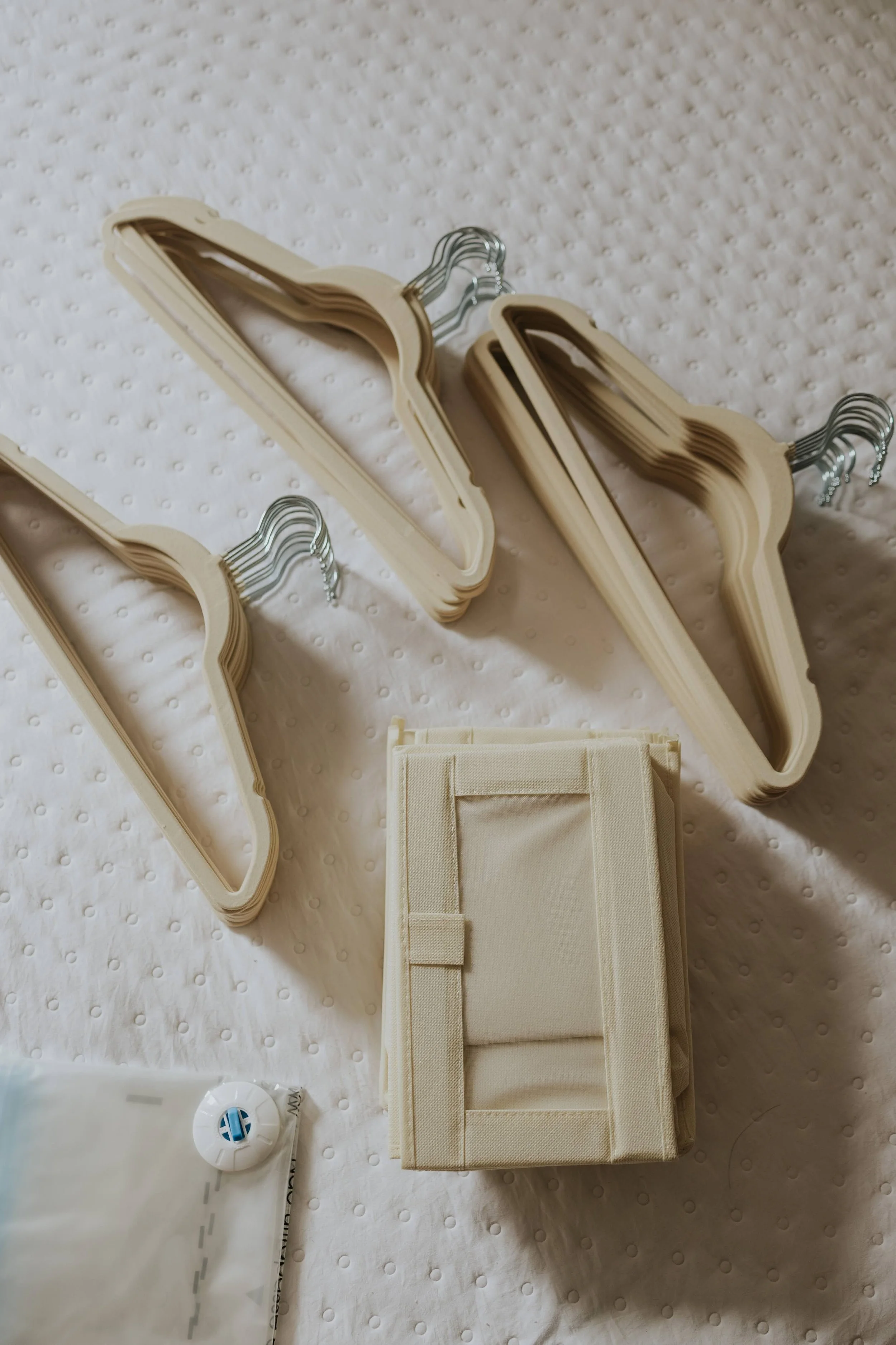 Empty hangers are neatly arranged on a bed after an in-home organizing and decluttering session in Omaha, NE.
