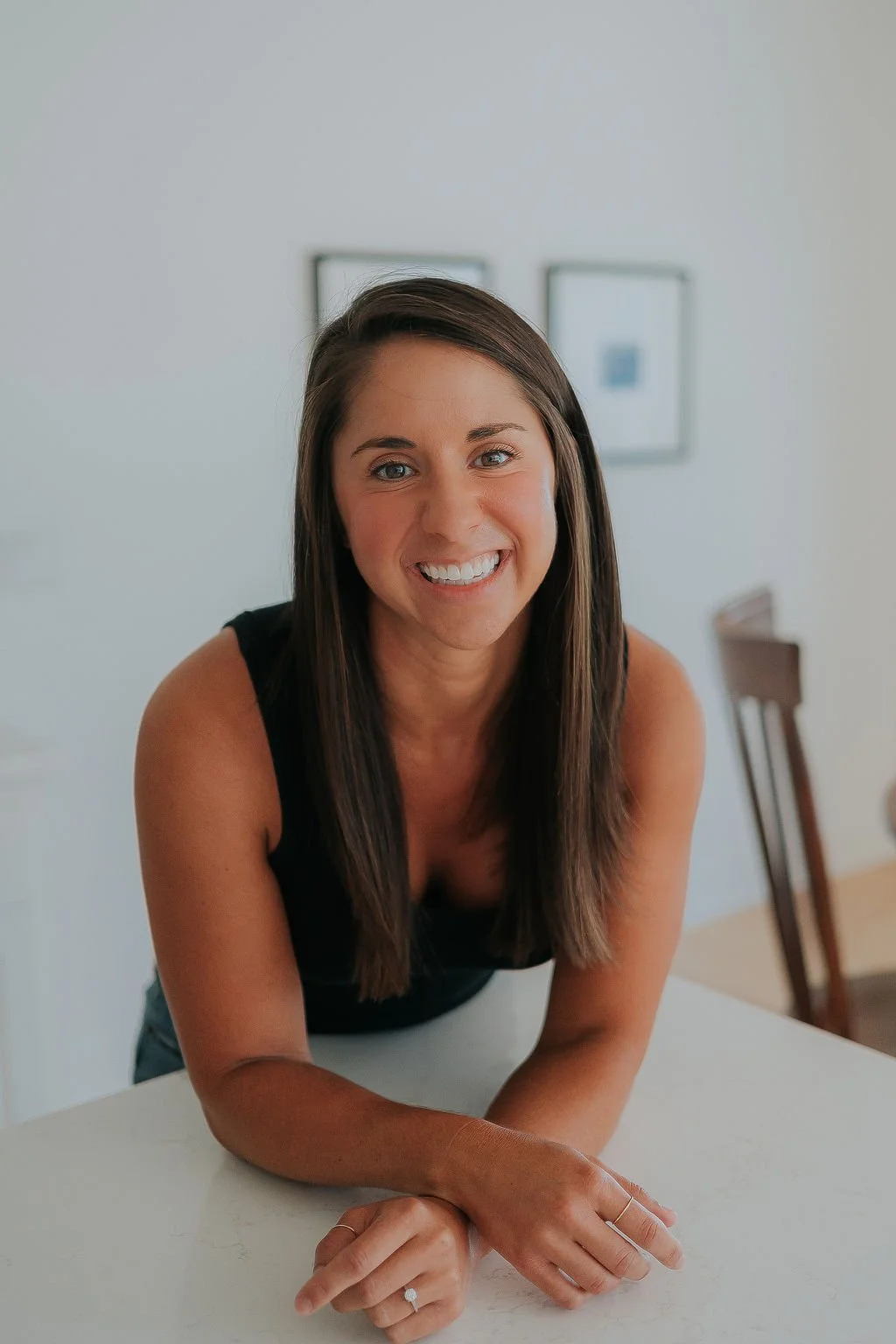 Professional Organizer for ADHD and founder of Happy Home Decluttering + Organization, Melissa Welch, smiles with her arms crossed leaning against an organized kitchen counter.