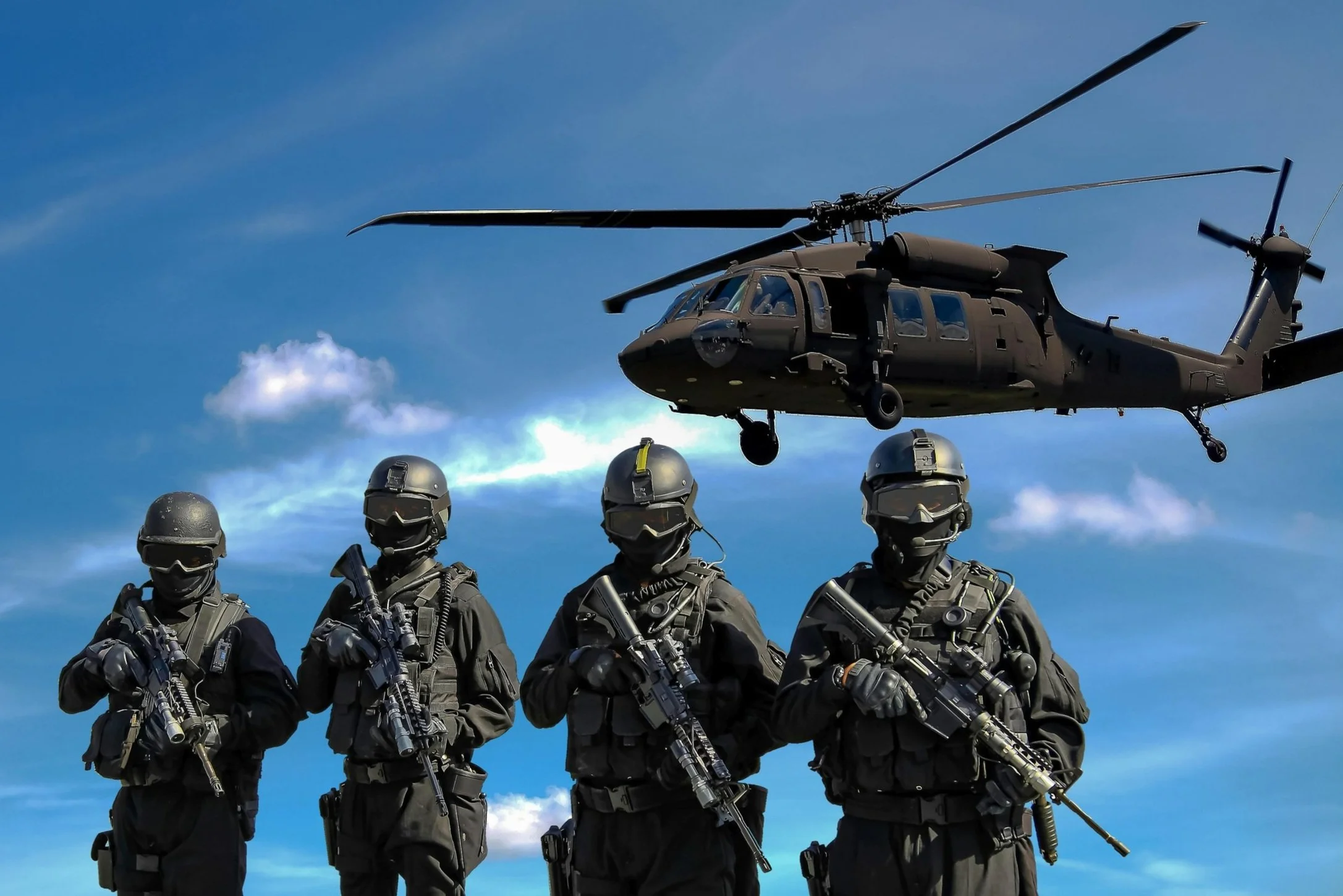 Helicopter flying with soldiers standing by