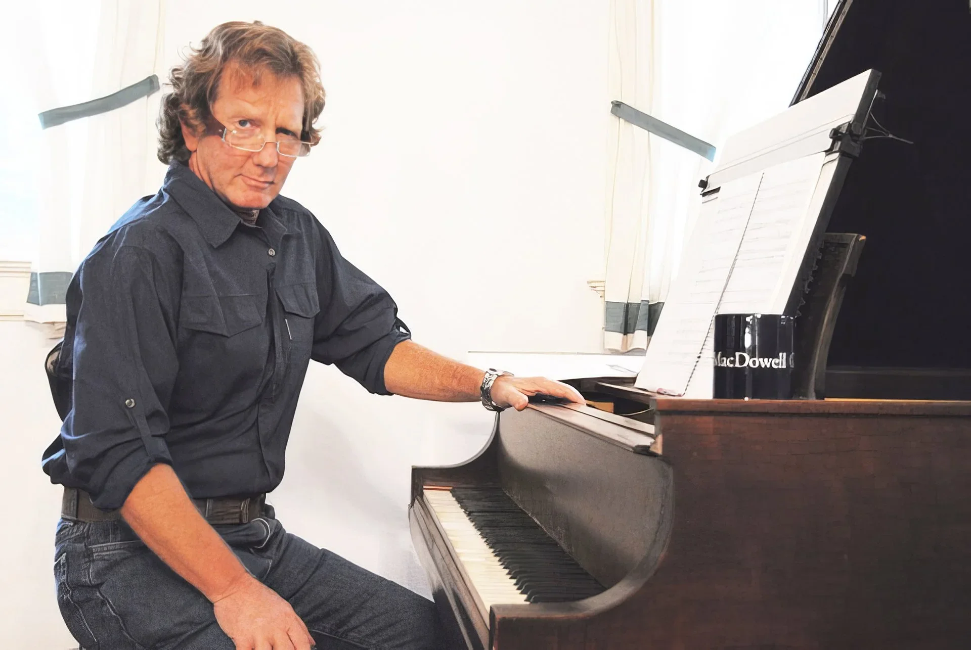 Hank Hehmsoth at the MacDowell Colony composer residency in Watson Studio seated at piano