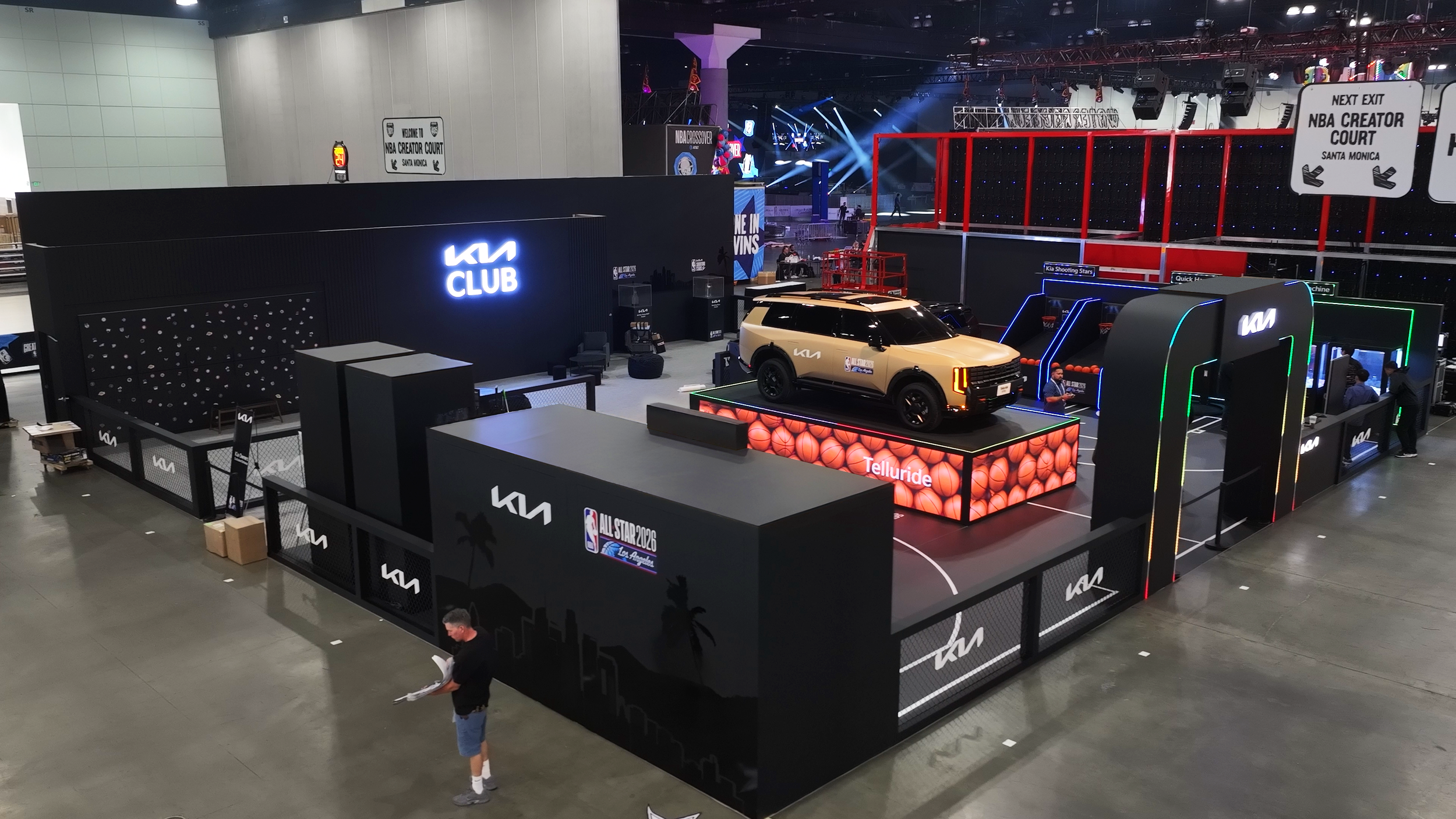 Sleek Black Booth of KIA Exhibit at NBA All-Star 2026. A car stands on top of an LED fixture in the middle of the booth surrounded by sleek black walls and structures. Designed and created by MEGA Exhibit.