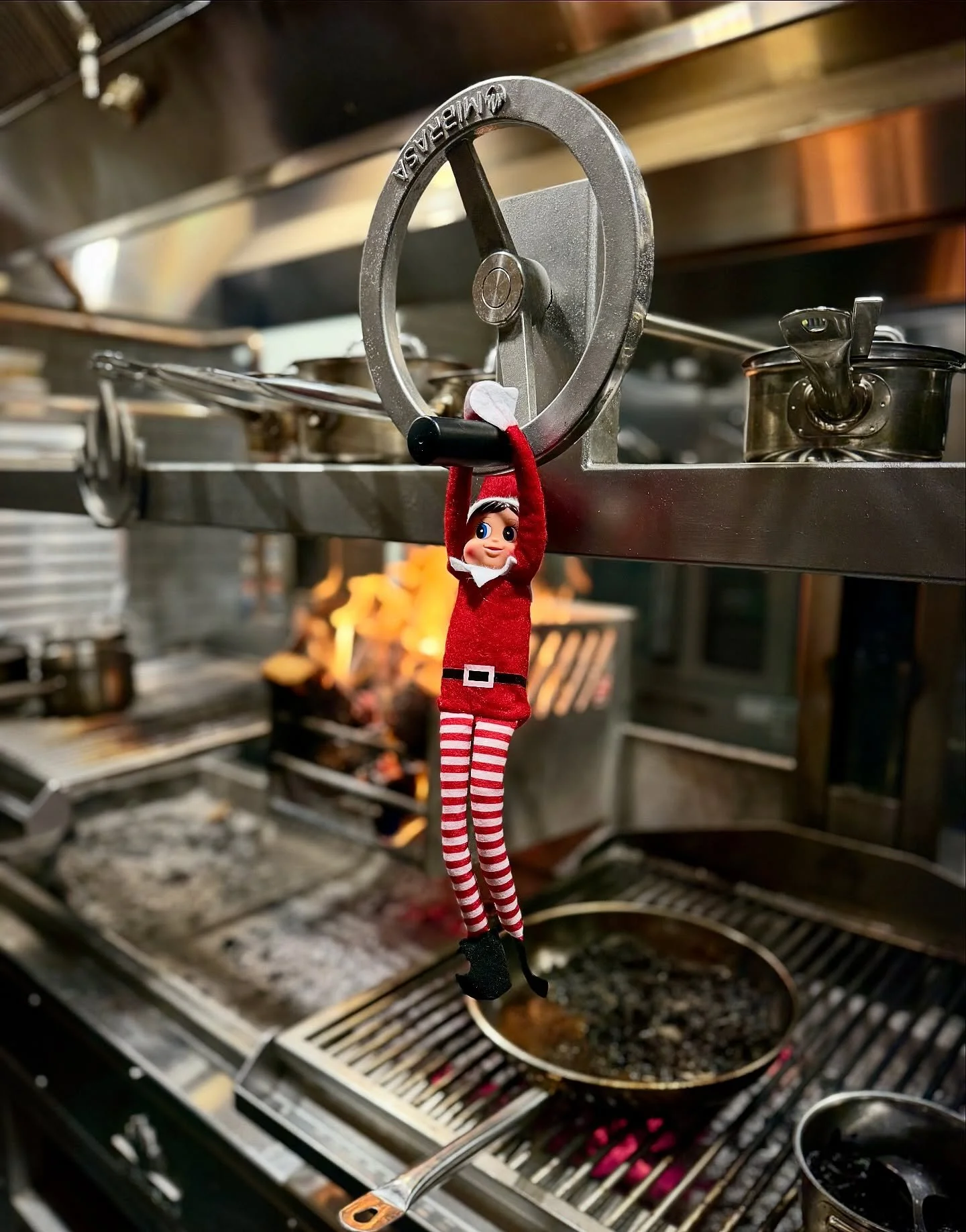 Stella&rsquo;s wood-fired grill is already dramatic enough with its flames, smoke, and general &ldquo;don&rsquo;t touch that&rdquo; energy, and now our elf has decided he&rsquo;s part of the brigade. He&rsquo;s out here hanging from the @mibrasa whee