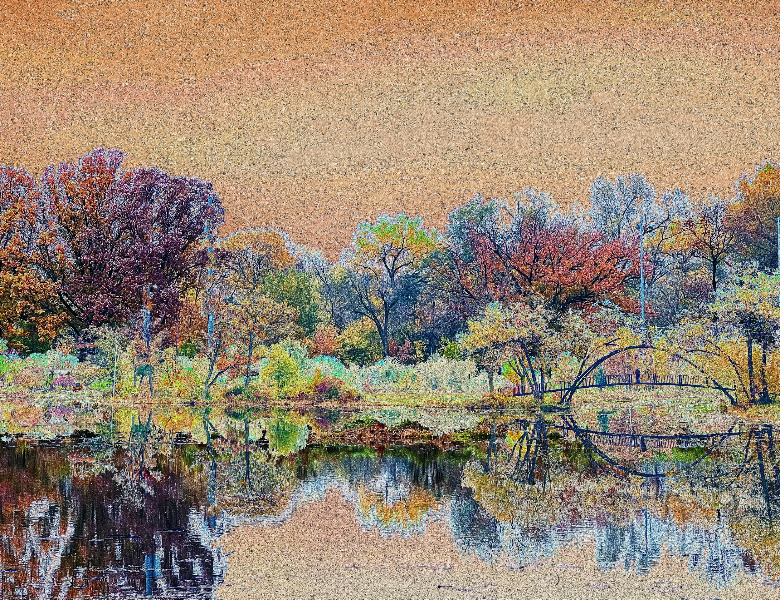 Colorful autumn trees with vibrant red, orange, yellow, purple, and green leaves reflected in a calm river at sunset.