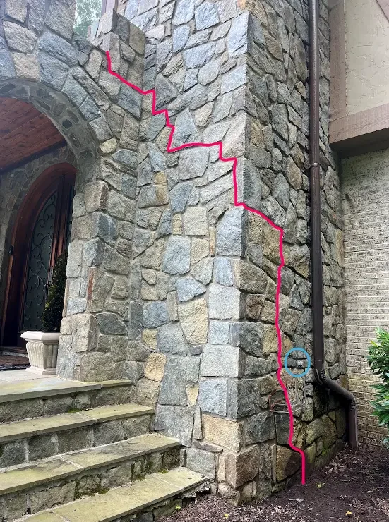 Image of a brick facade marked up to show client where wiring would be installed.
