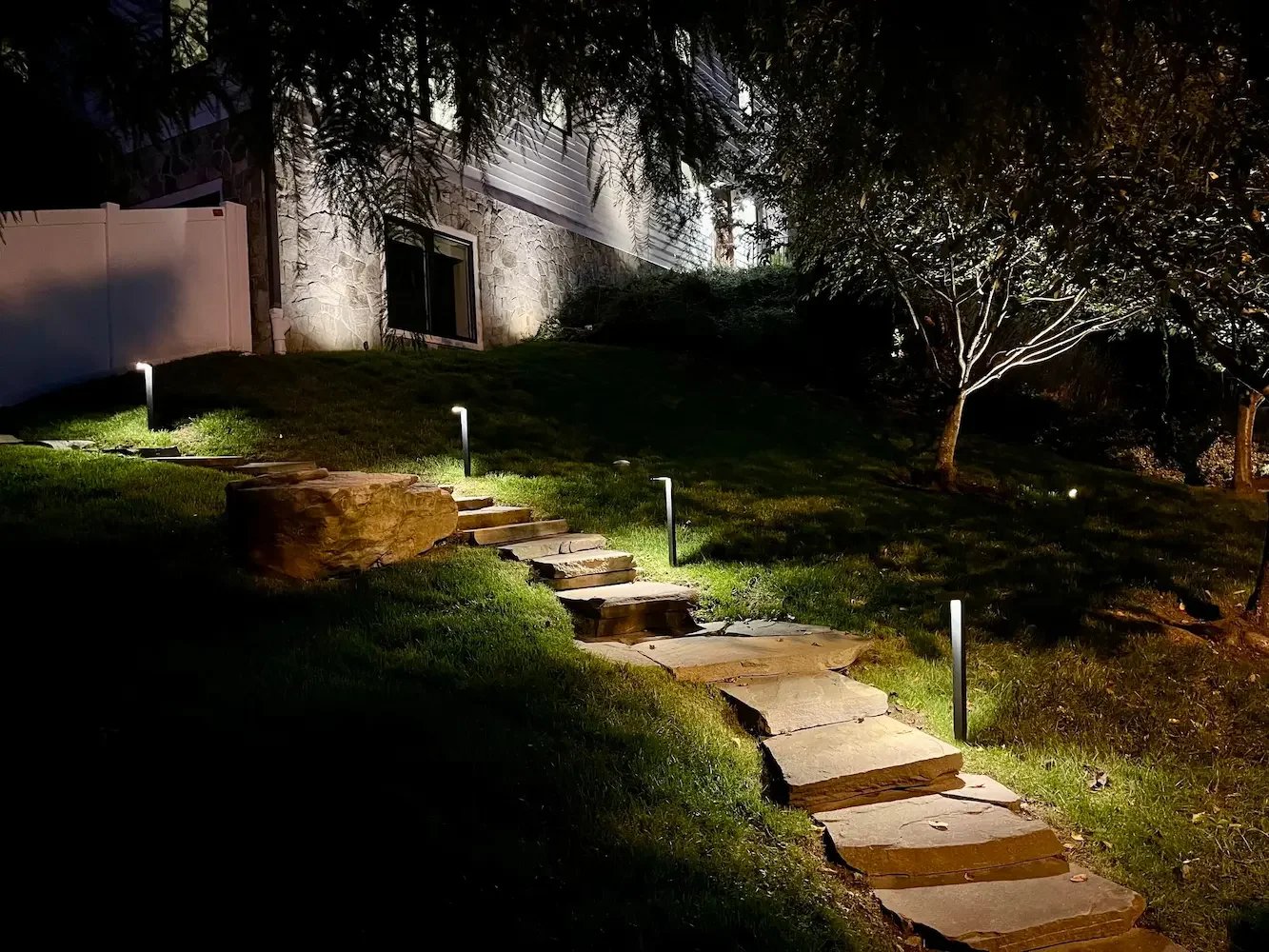 Contemporary black path light fixtures on stone steps.
