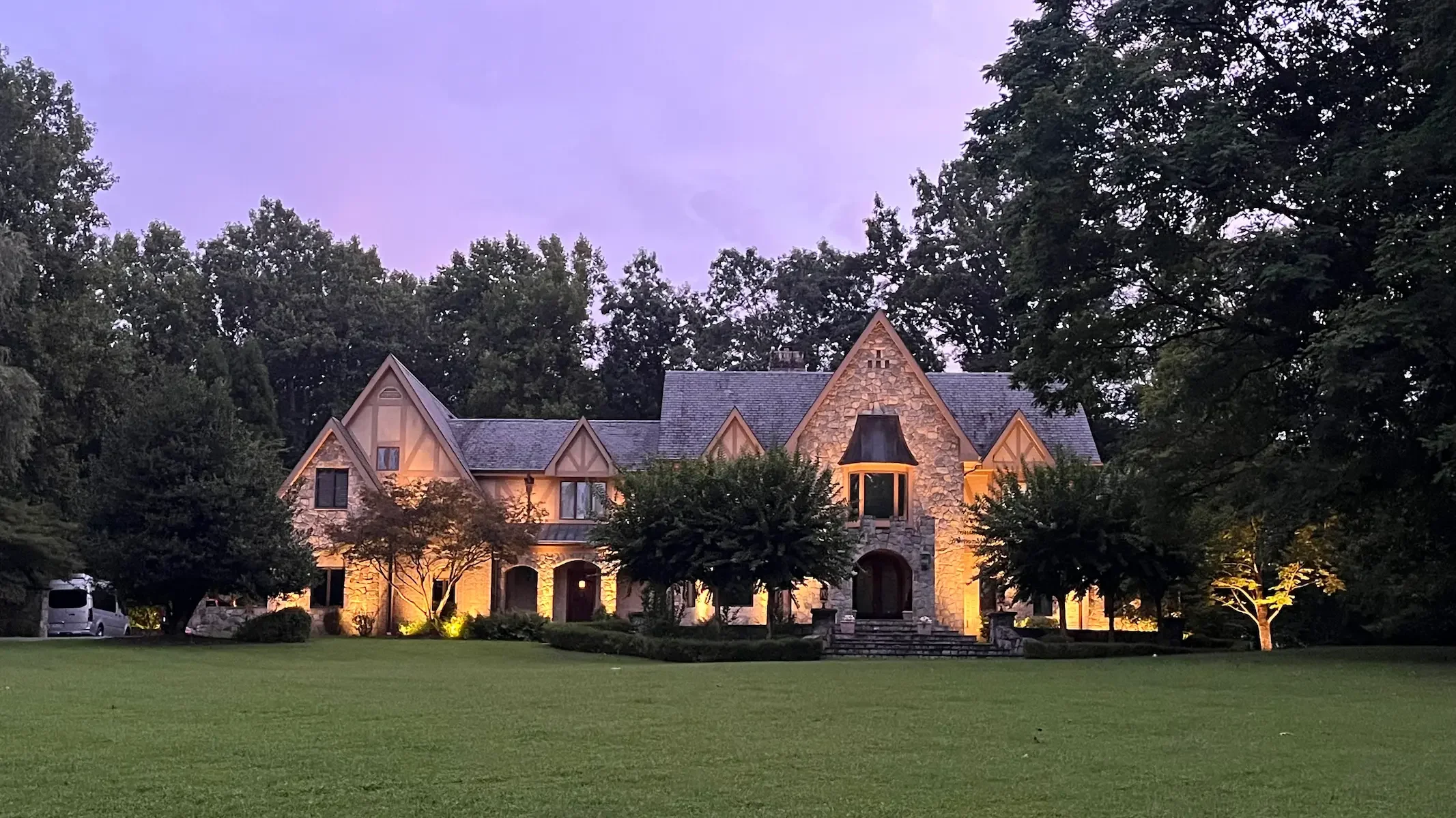 Layered lighting on this Great Falls estate highlights the stonework, emphasizes the architectural rhythm, and illuminates up to the roofline.
