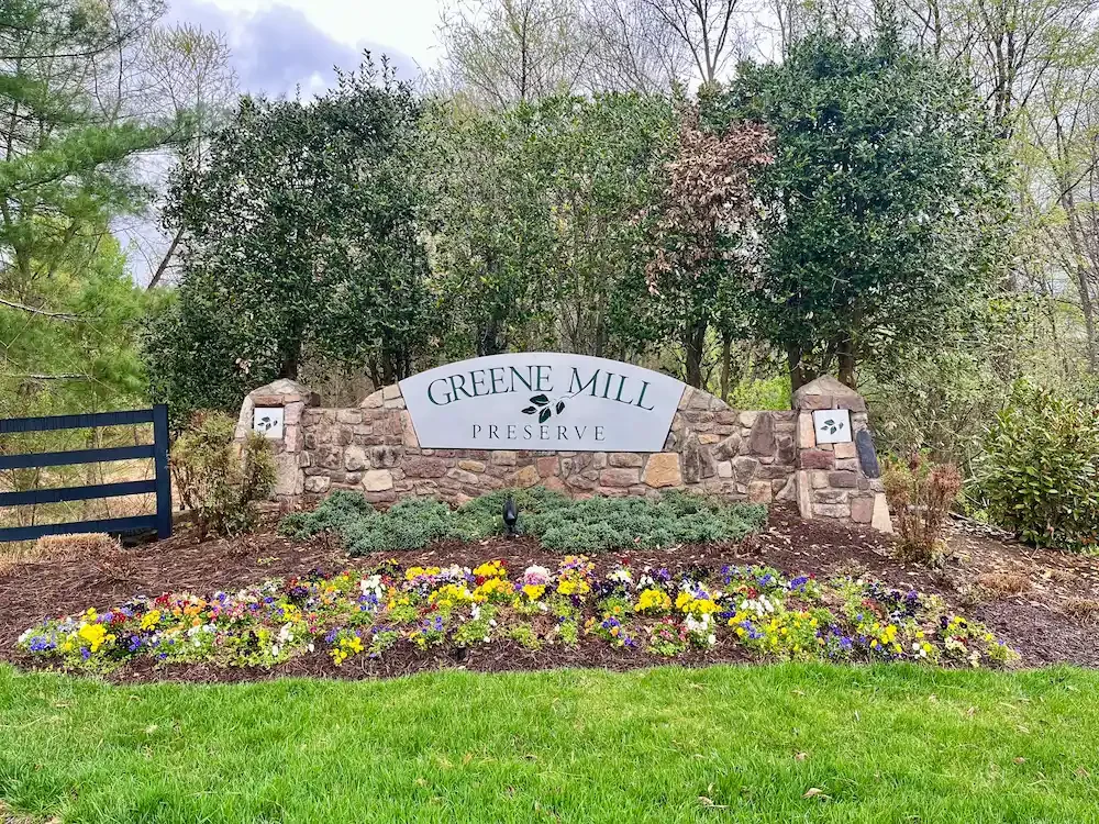 Greene Mill Preserve sign surrounded by greenery and flowers