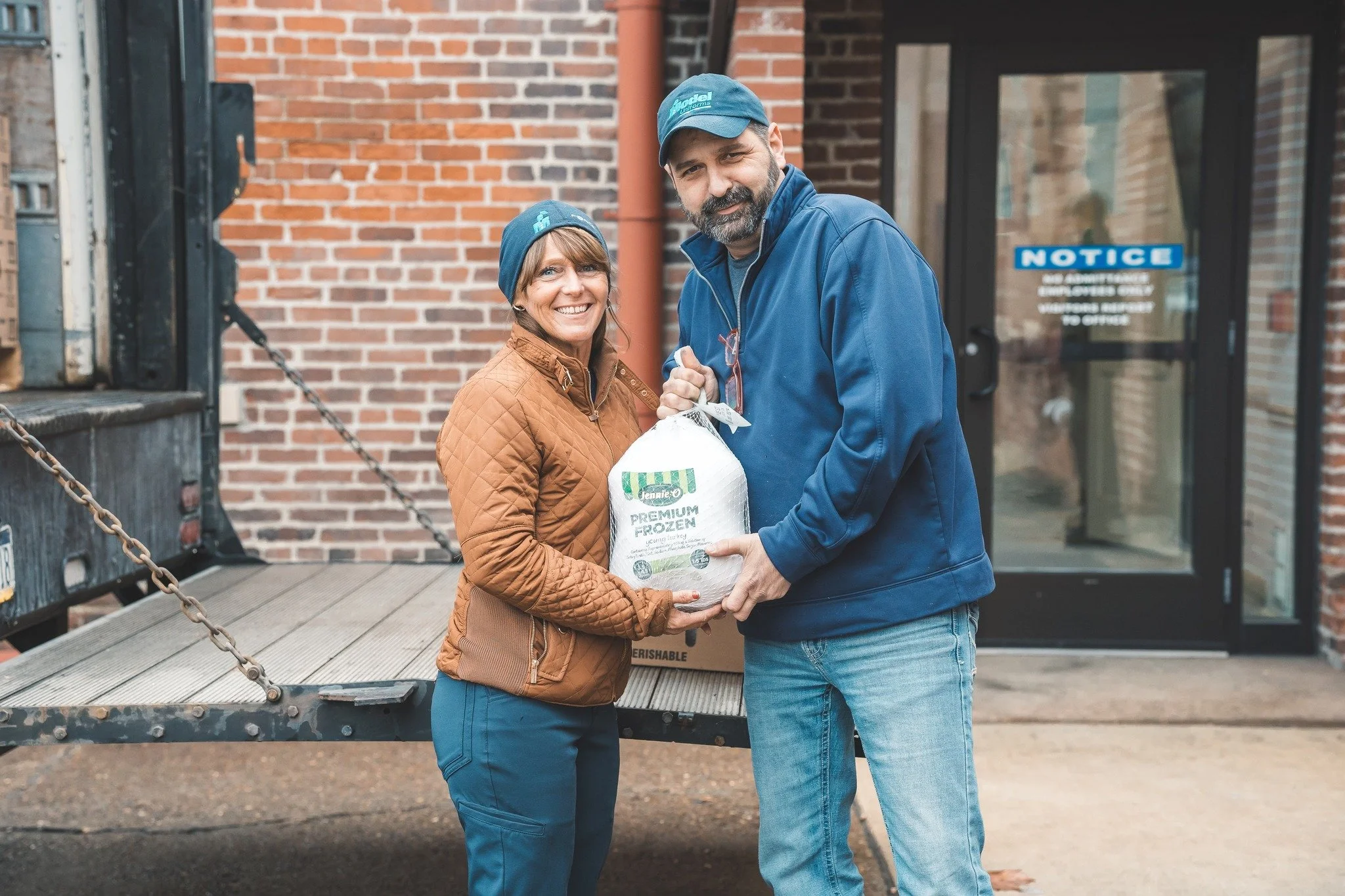 Model Cleaners team members donating a frozen turkey during a community event in Pittsburgh