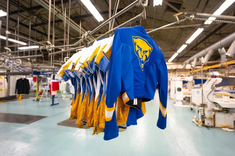 Professionally cleaned Pittsburgh sports uniforms hanging inside the Model Cleaners facility