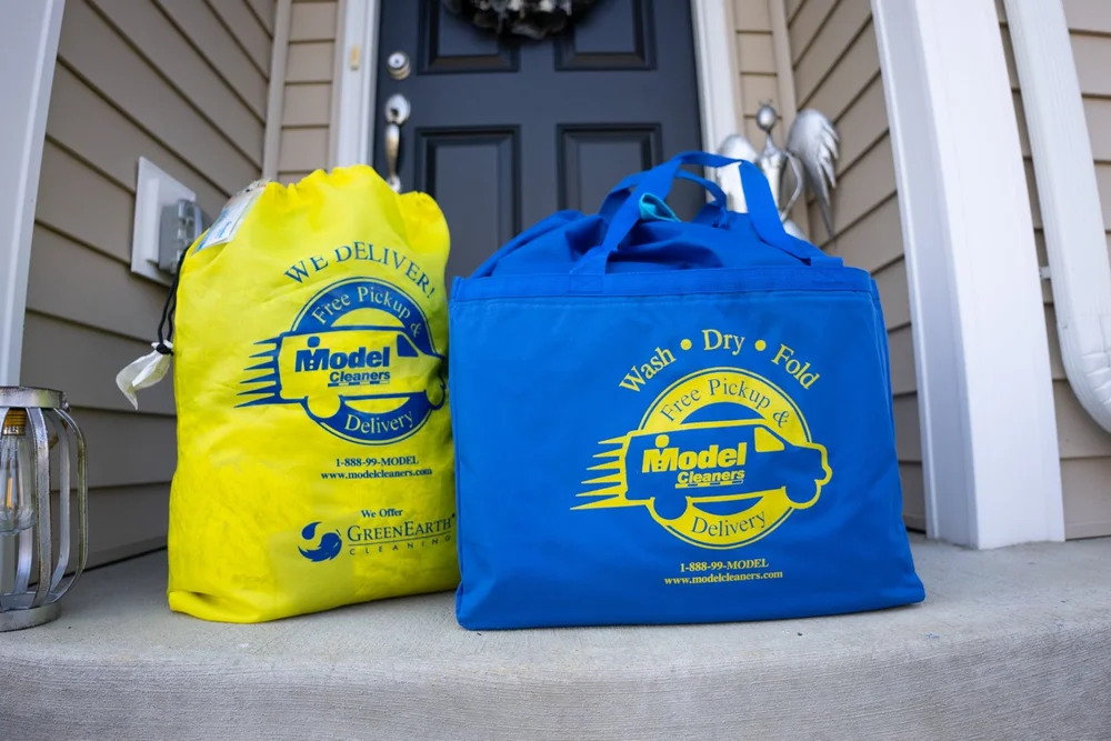 Yellow Model Cleaners pickup and delivery bags placed outside a customer's door for Western PA dry cleaning service
