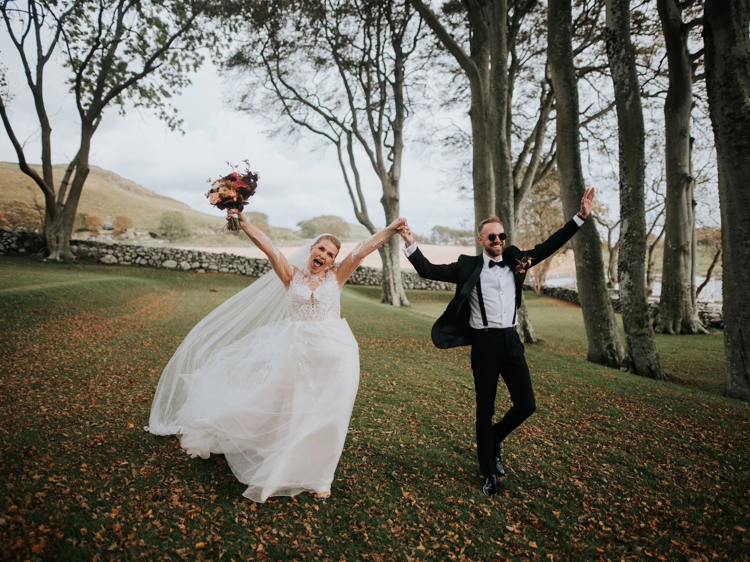 Et brudepar i parken utenfor Utstein Kloster en høstdag