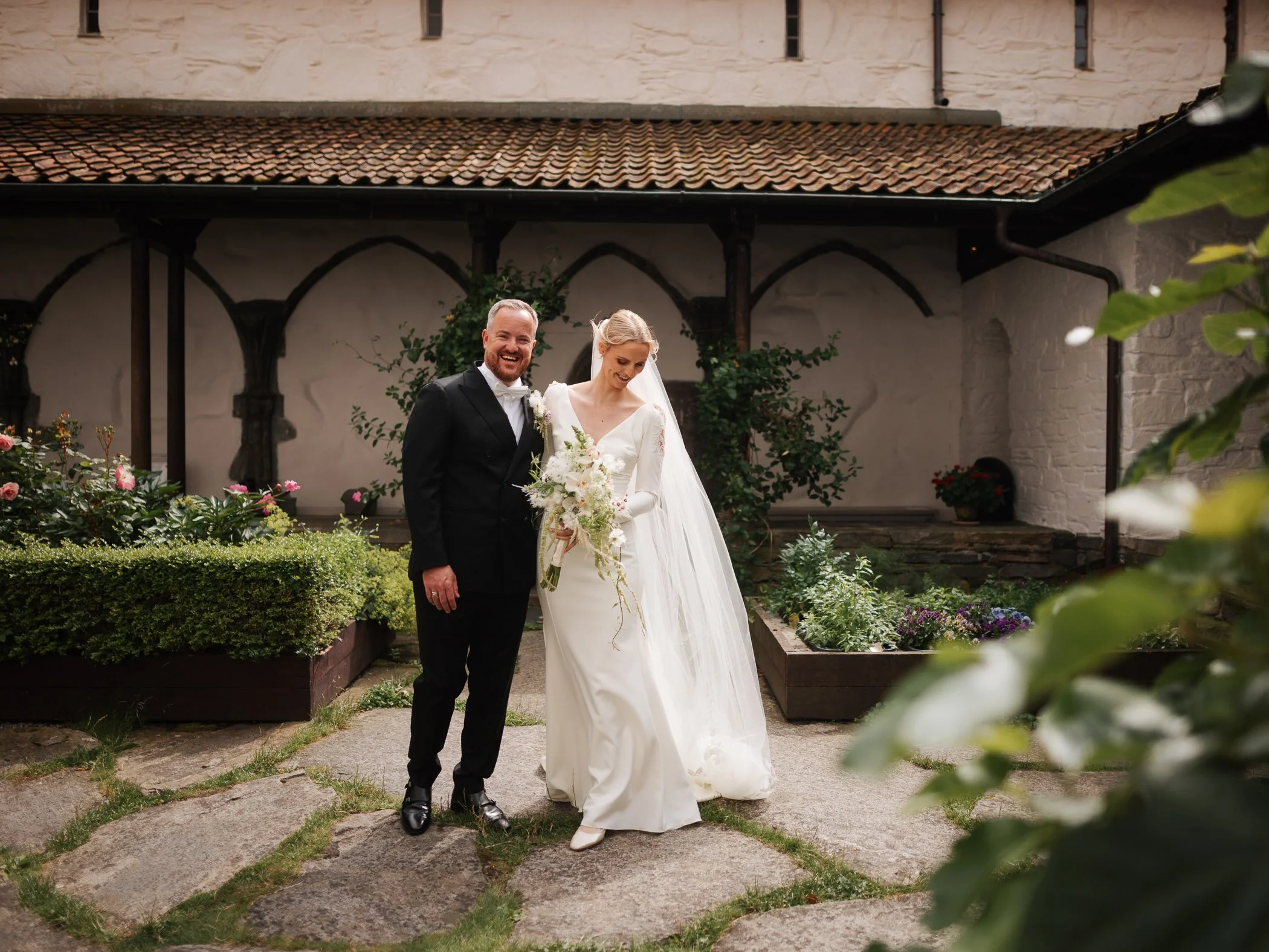 Brudepar under bryllup på Mosterøy, fotografert i klosterhagen på Utstein Kloster.