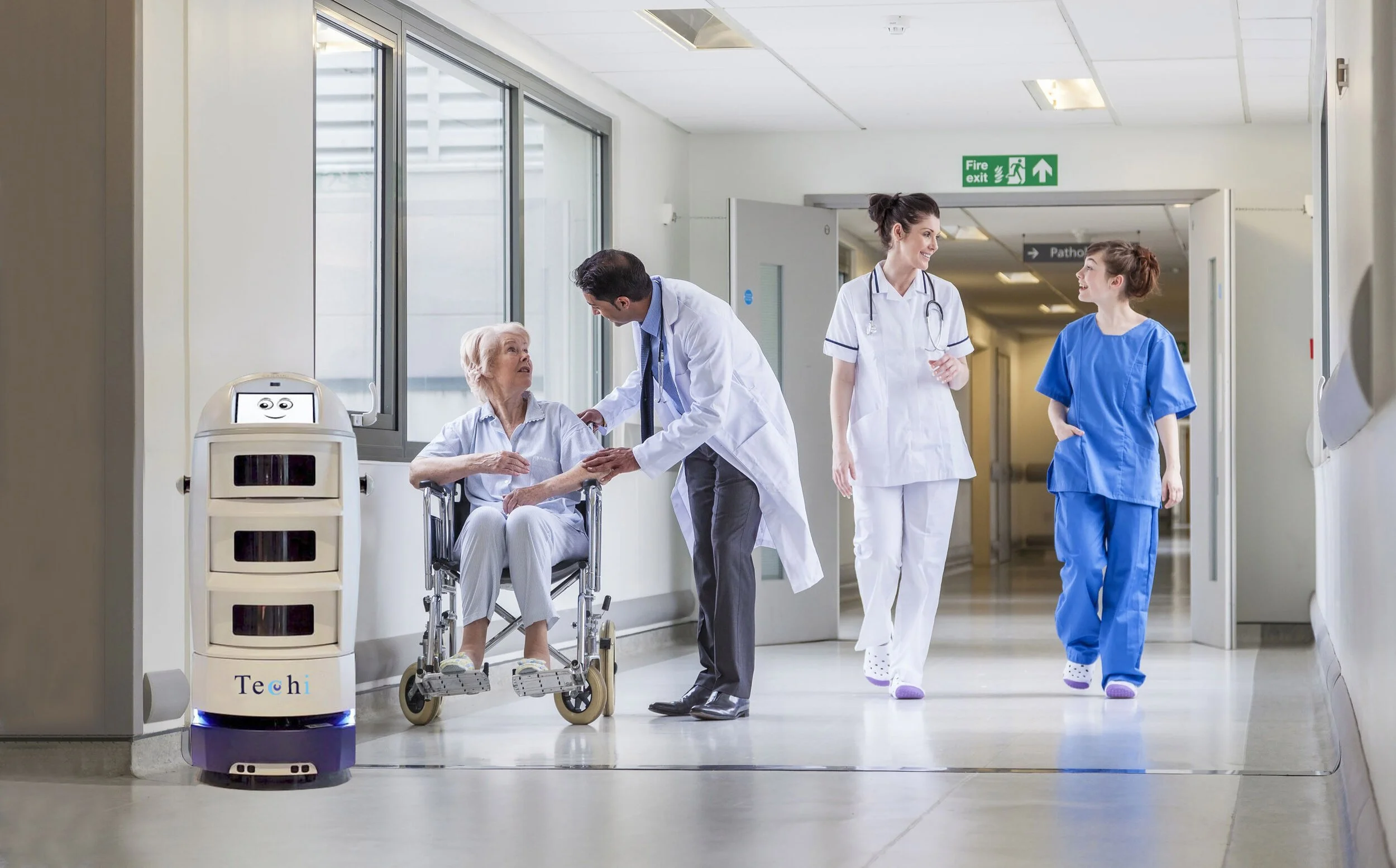 A nurse and a doctor visit an elderly woman in a hospital corridor. A medical robot named Techi stands nearby.