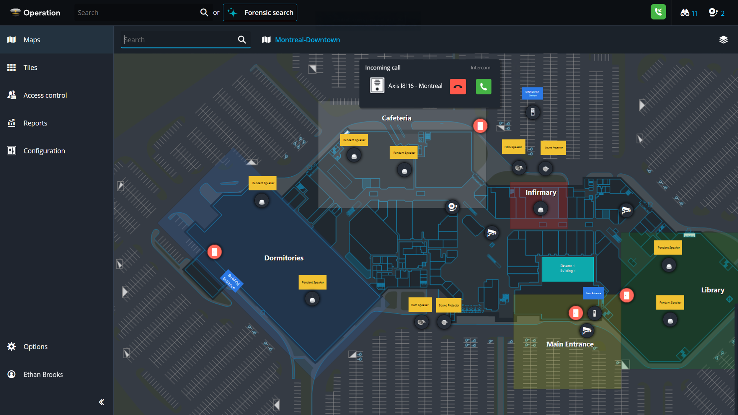 A detailed digital map of a hospital or medical facility, including labels for areas such as dormitories, infirmary, library, and main entrance. It displays parking lots, pathways, and rooms with symbols indicating communication points and facilities.