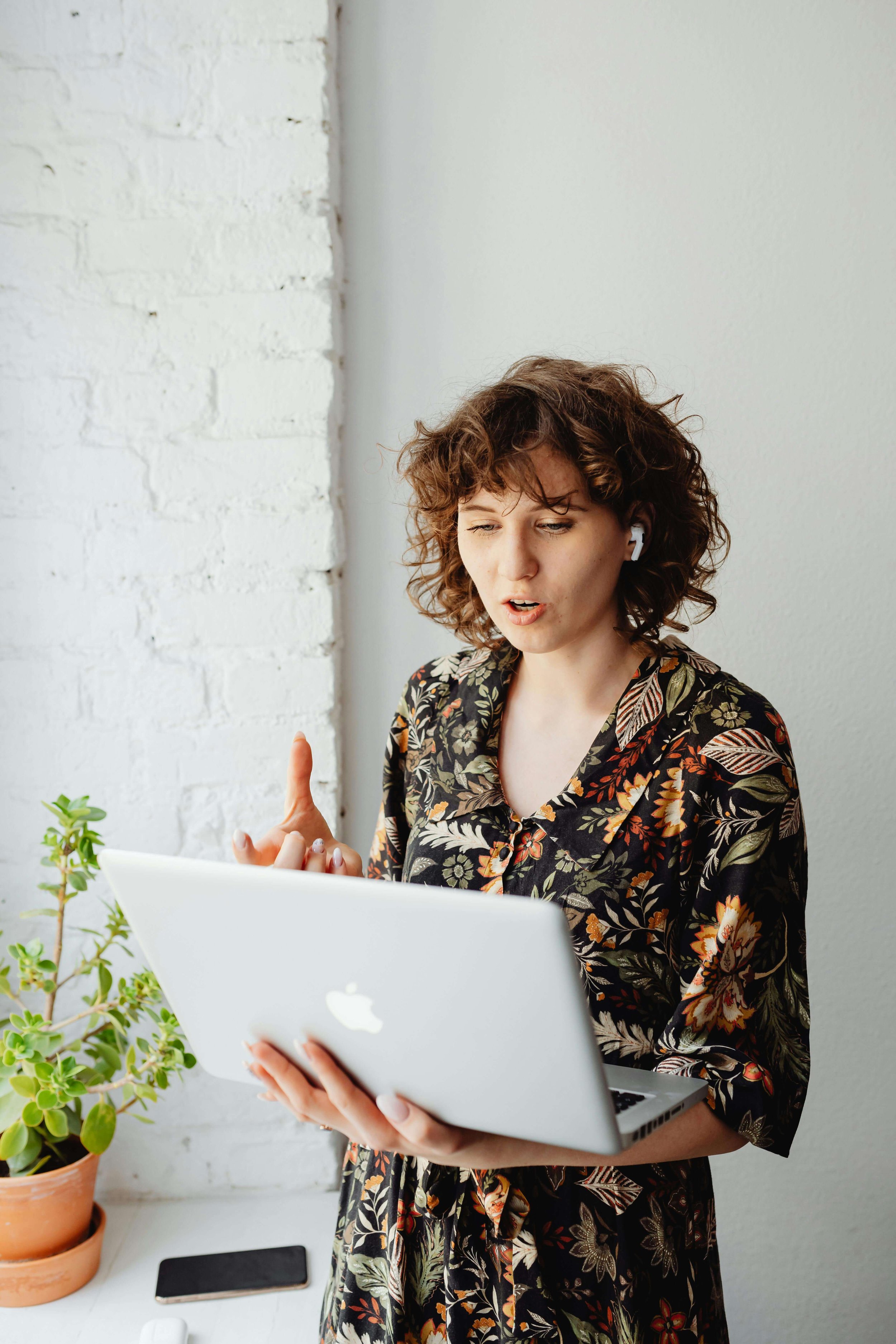 Woman on a call with her laptop, mid-conversation and already second-guessing herself — therapy for anxious perfectionists in Garden City, New York and online therapy for perfectionism in Garden City, New York can help you stop the replay.