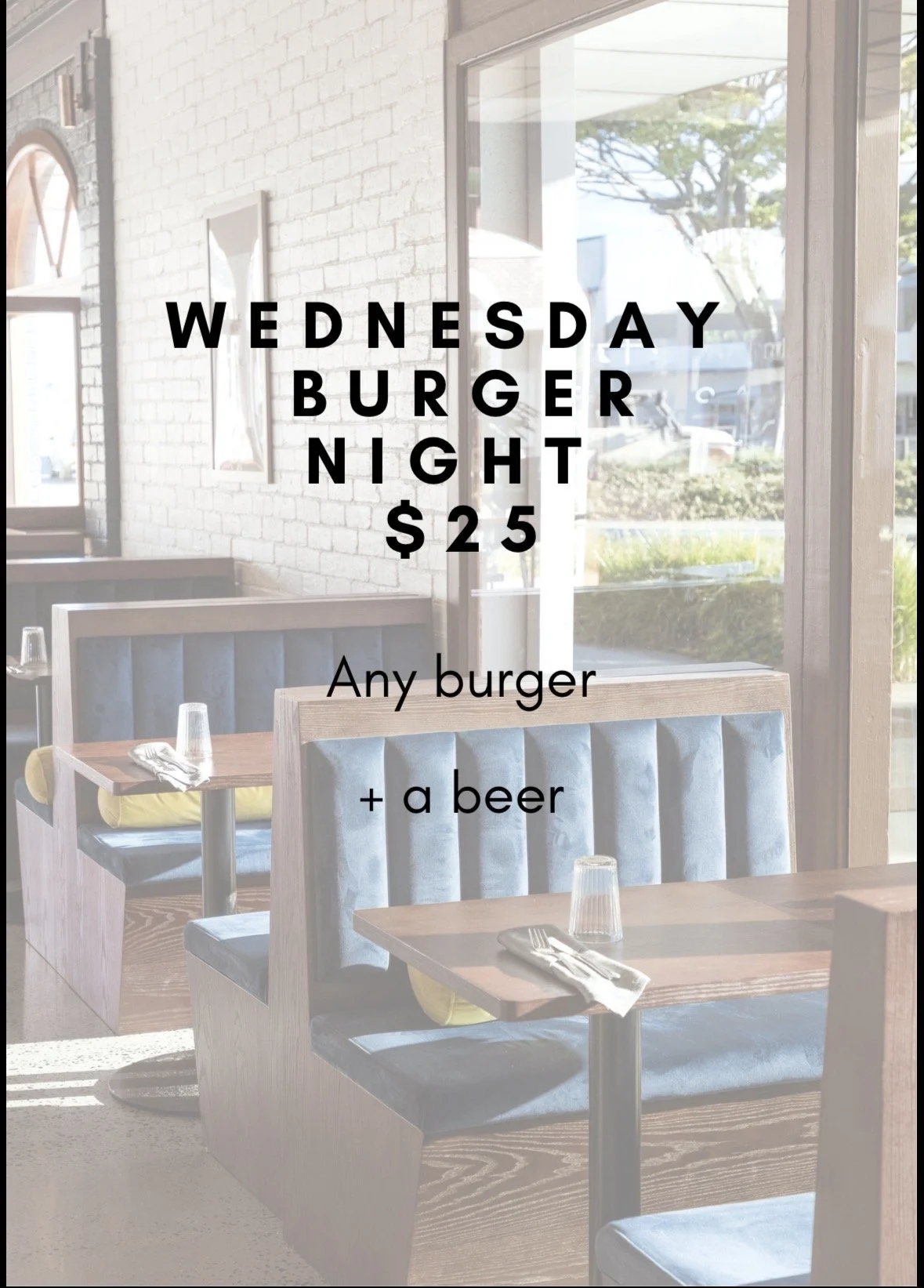 Restaurant window with a Wednesday burger night advertisement, offering any burger and a beer for $25. Inside the restaurant, there are tables set with glasses and utensils, and sunlight coming through the windows.