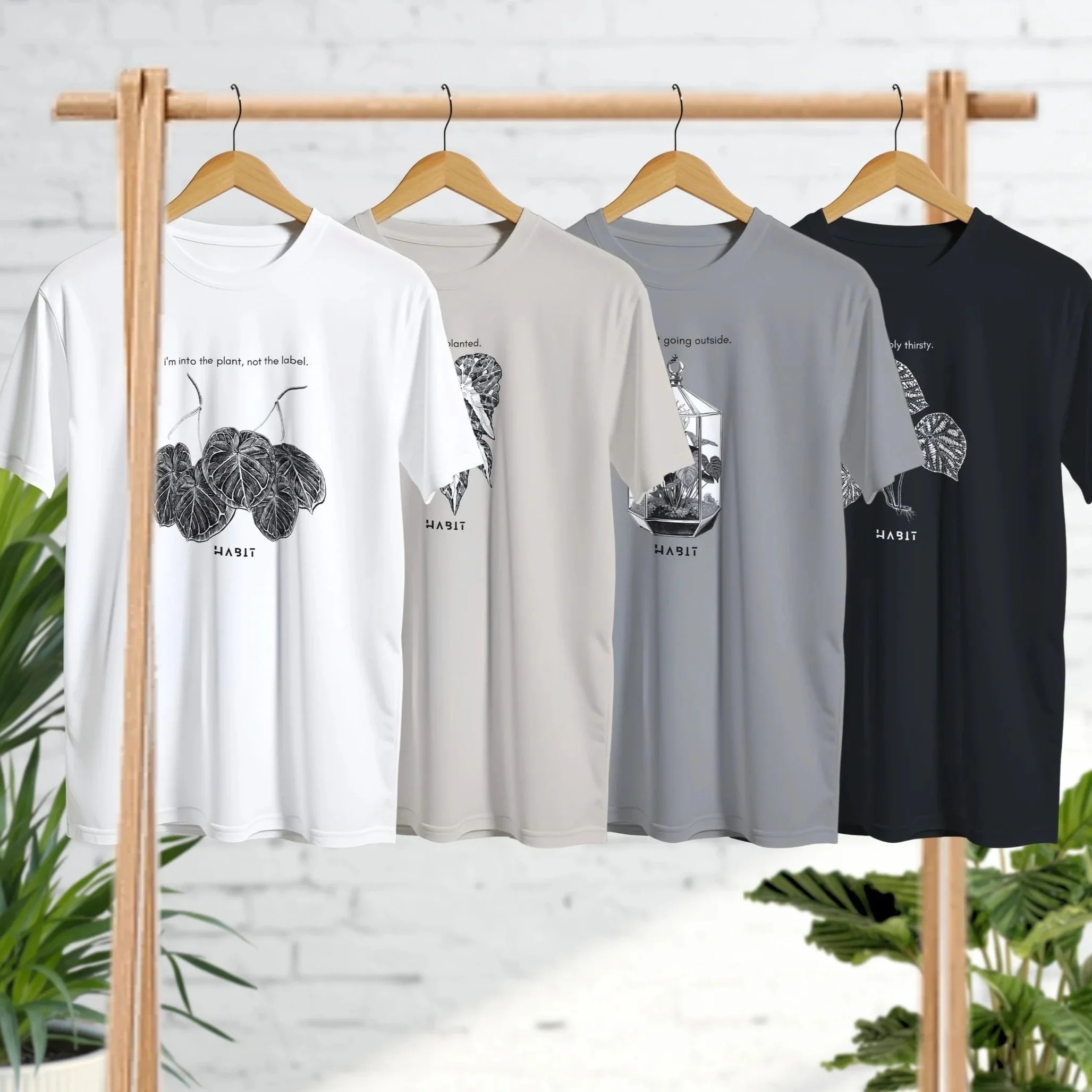 Two people wearing black hoodies with white floral and leaf designs and the word "HABIT" printed on the front.