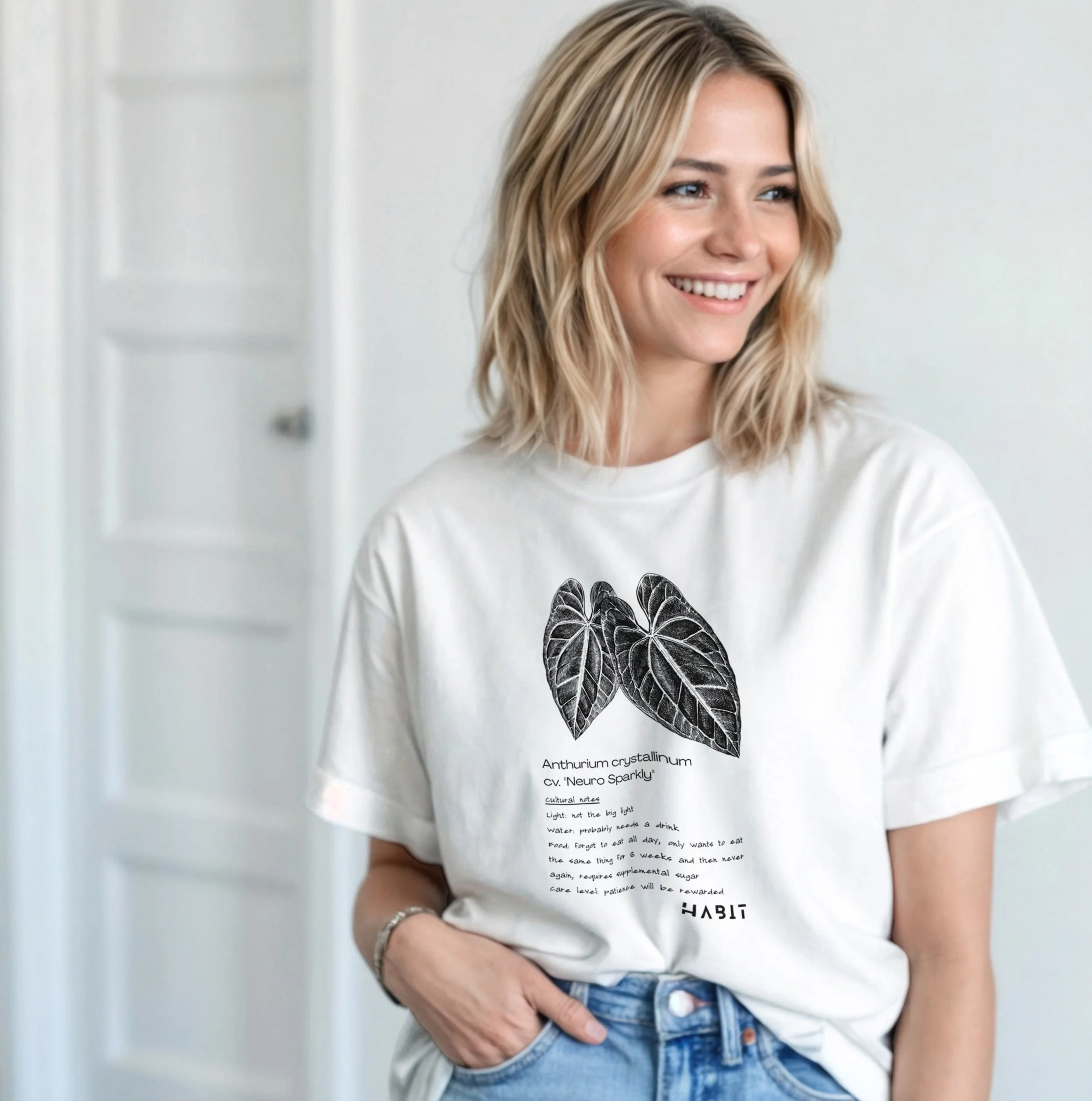Two people wearing black hoodies with white floral and leaf designs and the word "HABIT" printed on the front.