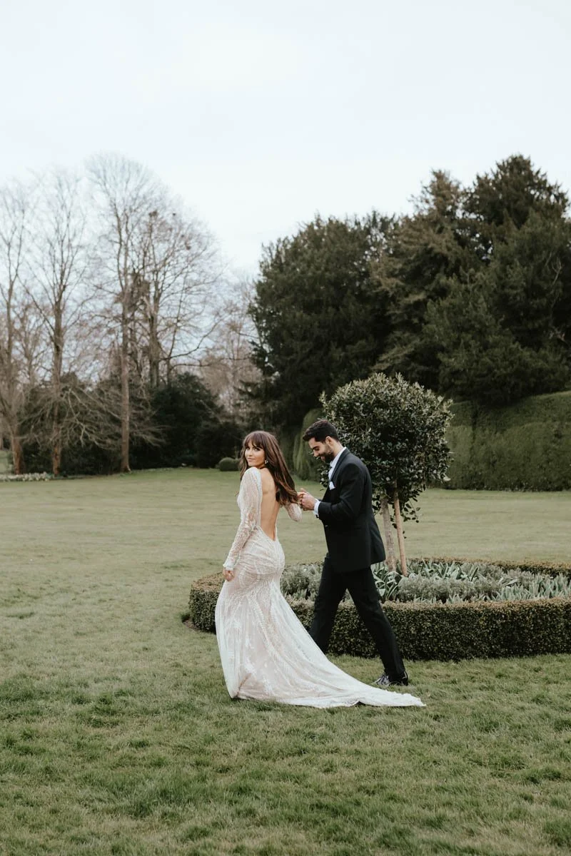 bride and groom walking through a garden
