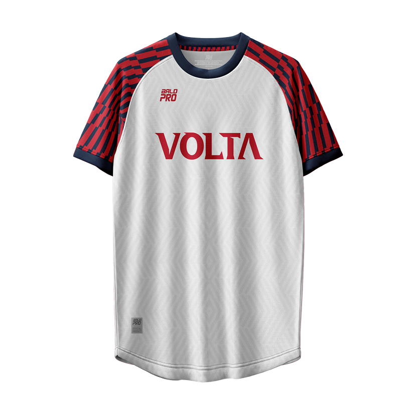 Ein weißes Sportshirt mit roten und blauen Mustern auf den Schultern und Ärmeln, dem Schriftzug 'VOLTA' in der Mitte, und kleineren Logos auf der linken Brustseite und unten rechts.