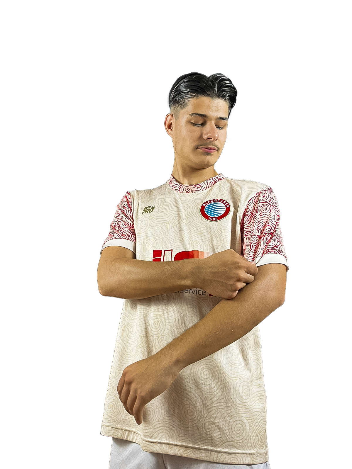 Ein junger Mann trägt ein weißes Trikot mit roten Mustern und einem Logo der Mannschaft BLAUBEUREN auf der Brust, posiert vor schwarzem Hintergrund.