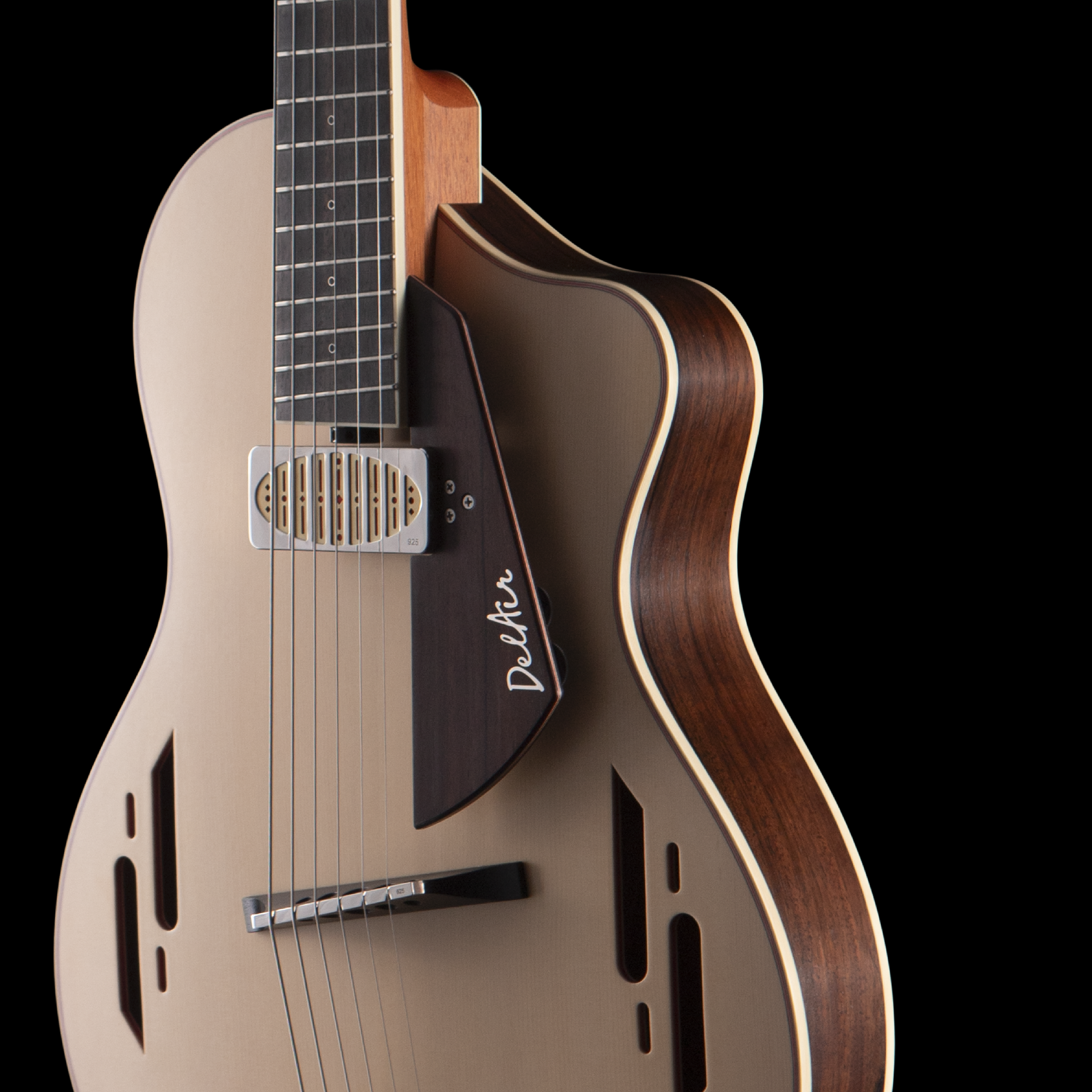 Close-up of an Island Instrument acoustic guitar with a white pickguard, wooden body, and black fretboard, against a black background.