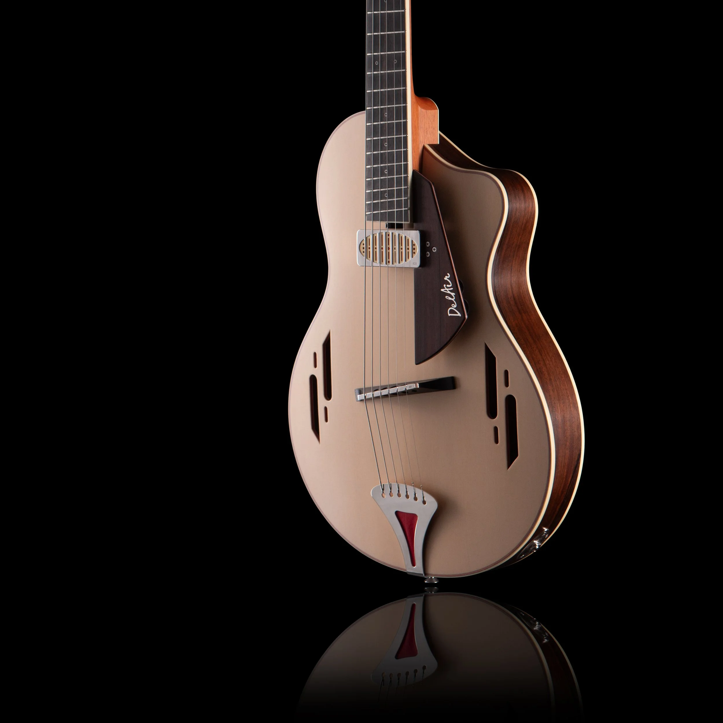 Close-up of an acoustic electric Island Instrument guitar with a natural wood finish, black fretboard, and metal strings, reflected on a glossy surface against a black background.