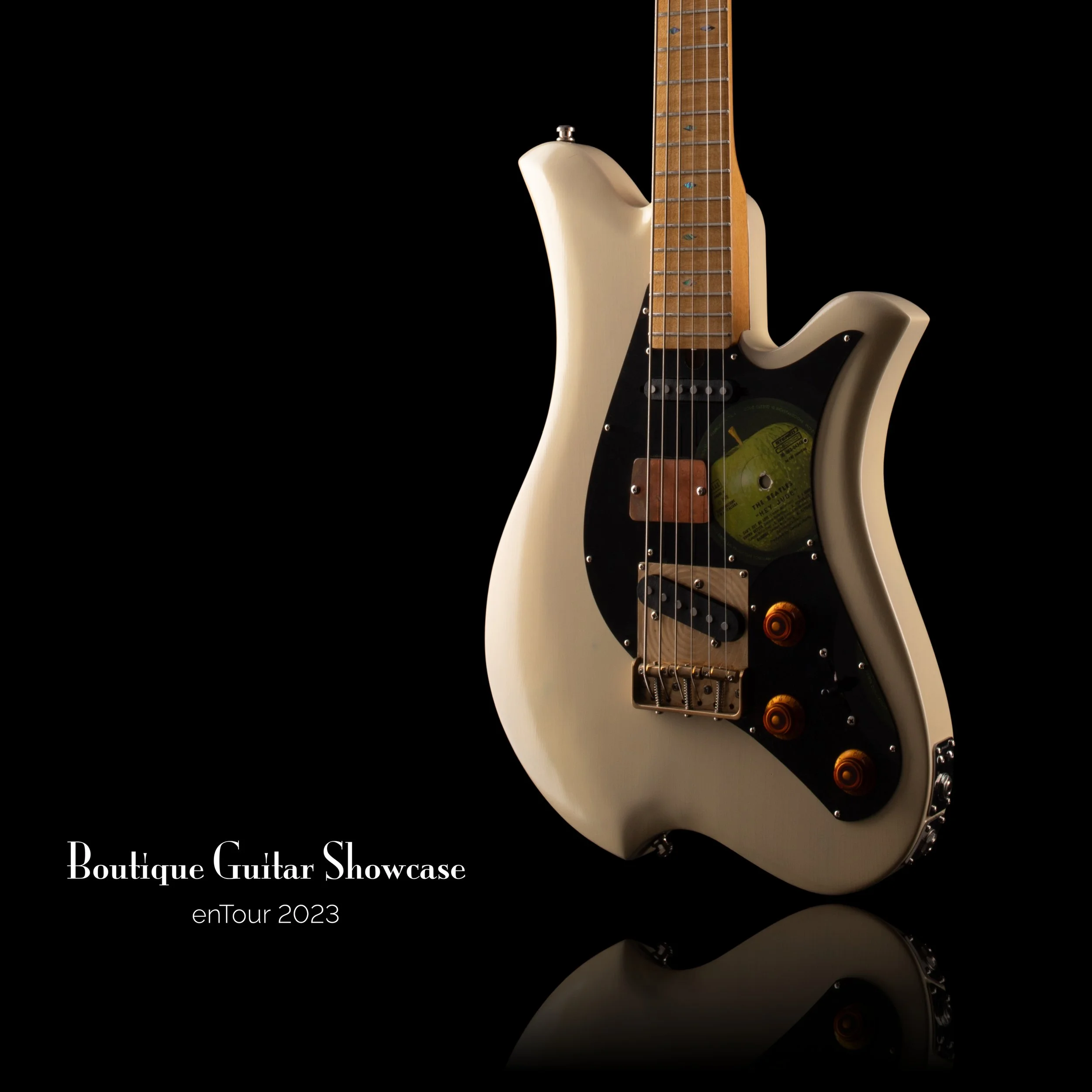 Bacci Baritone electric guitar with vintage design on black background showcasing text: 'Boutique Guitar Showcase enTour 2023.'