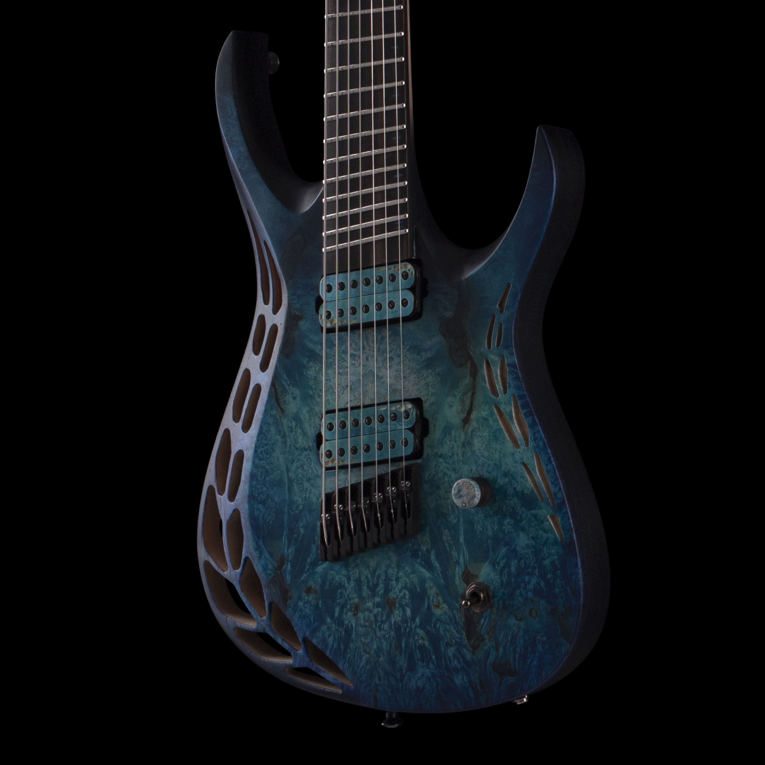 Close-up of a black and blue electric OD guitar with metallic strings and a perforated body, set against a black background.
