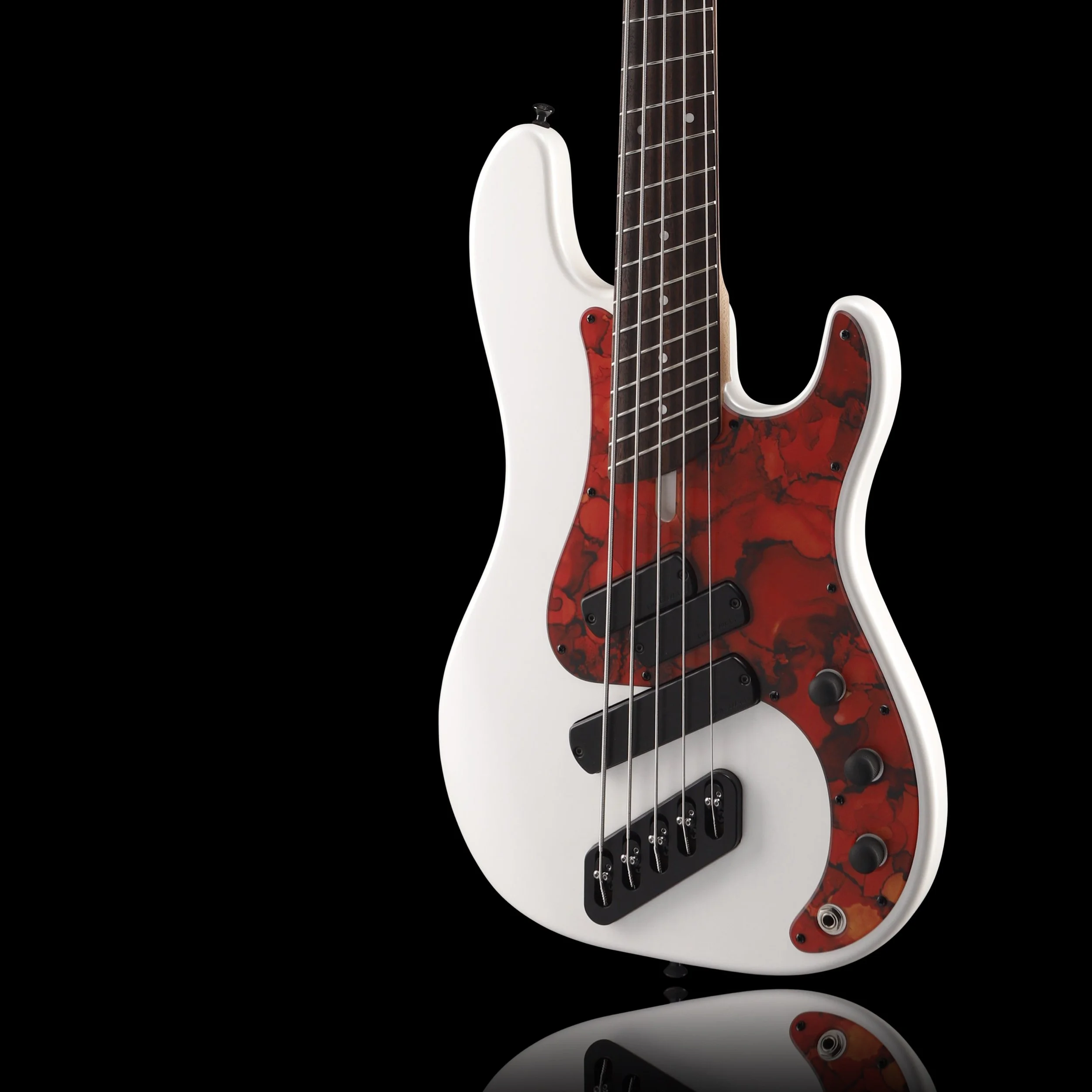 Electric Dingwall bass guitar with a white body, red marbled pickguard, and black hardware, reflected on a black surface