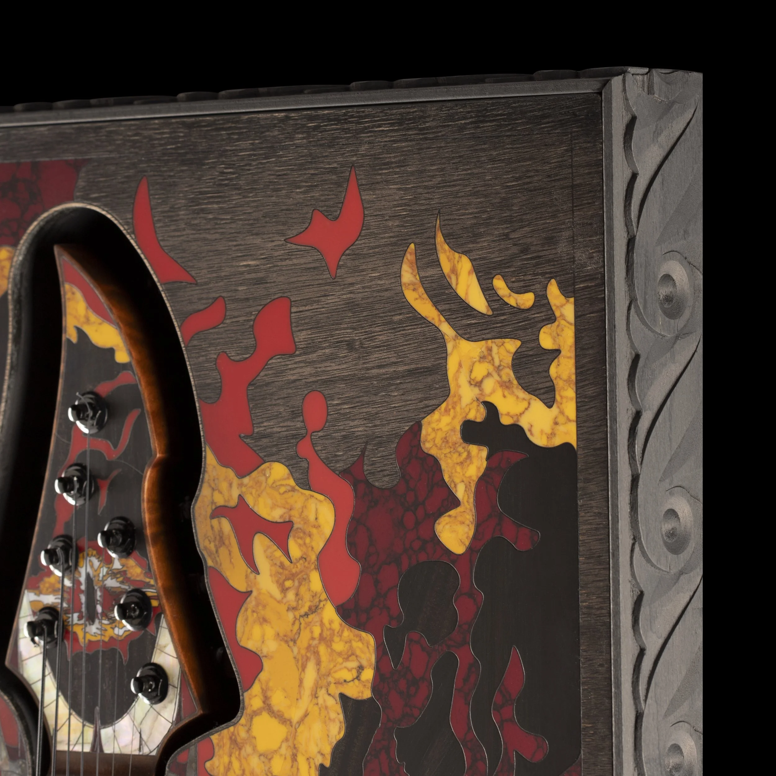 Close-up of a GNG Giulio Negrin guitar with flame motif painted on the body, placed next to other guitars with similar design.