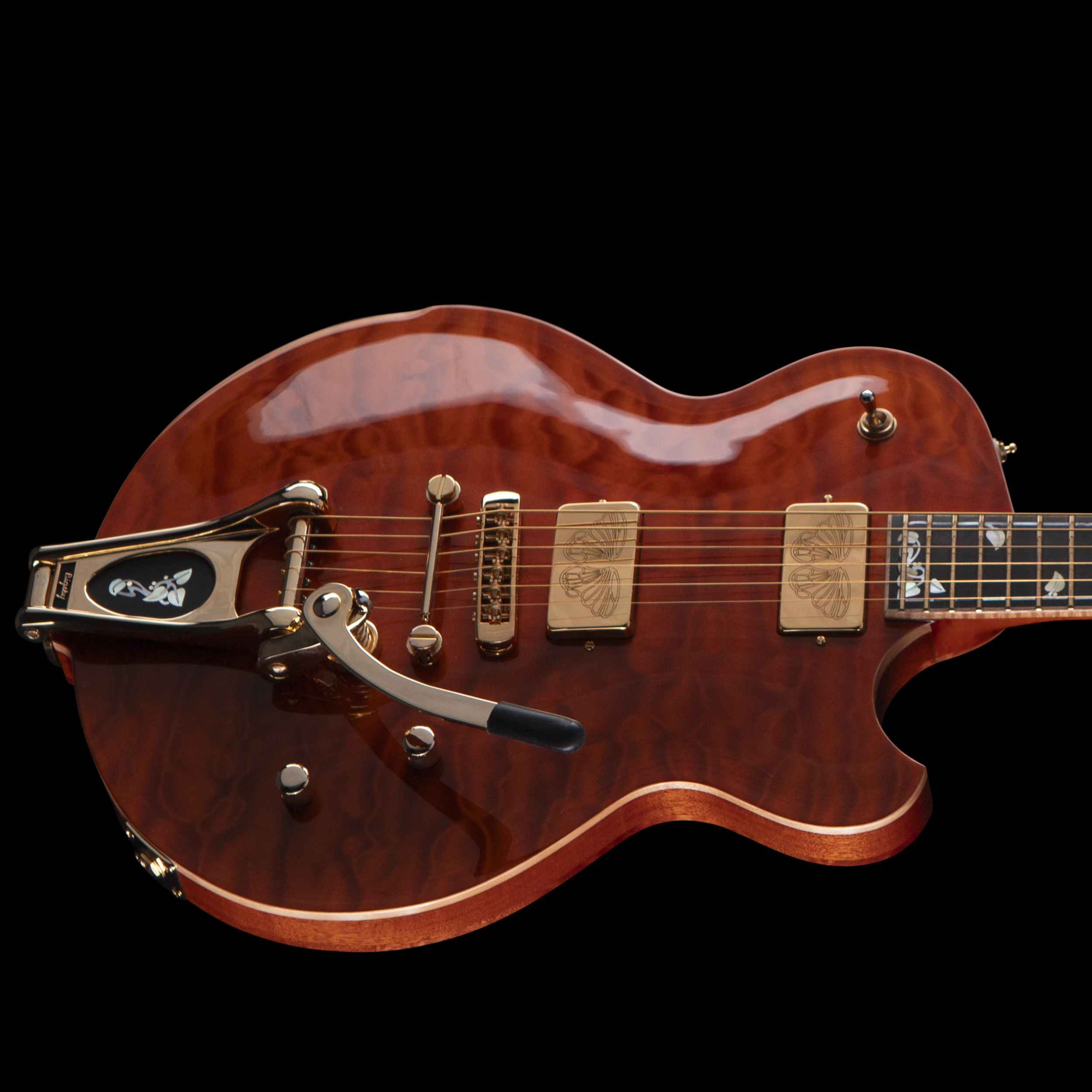 Close-up of an electric Djerjinski guitar's body showing its wood grain finish, chrome hardware, and part of the neck against a black background.