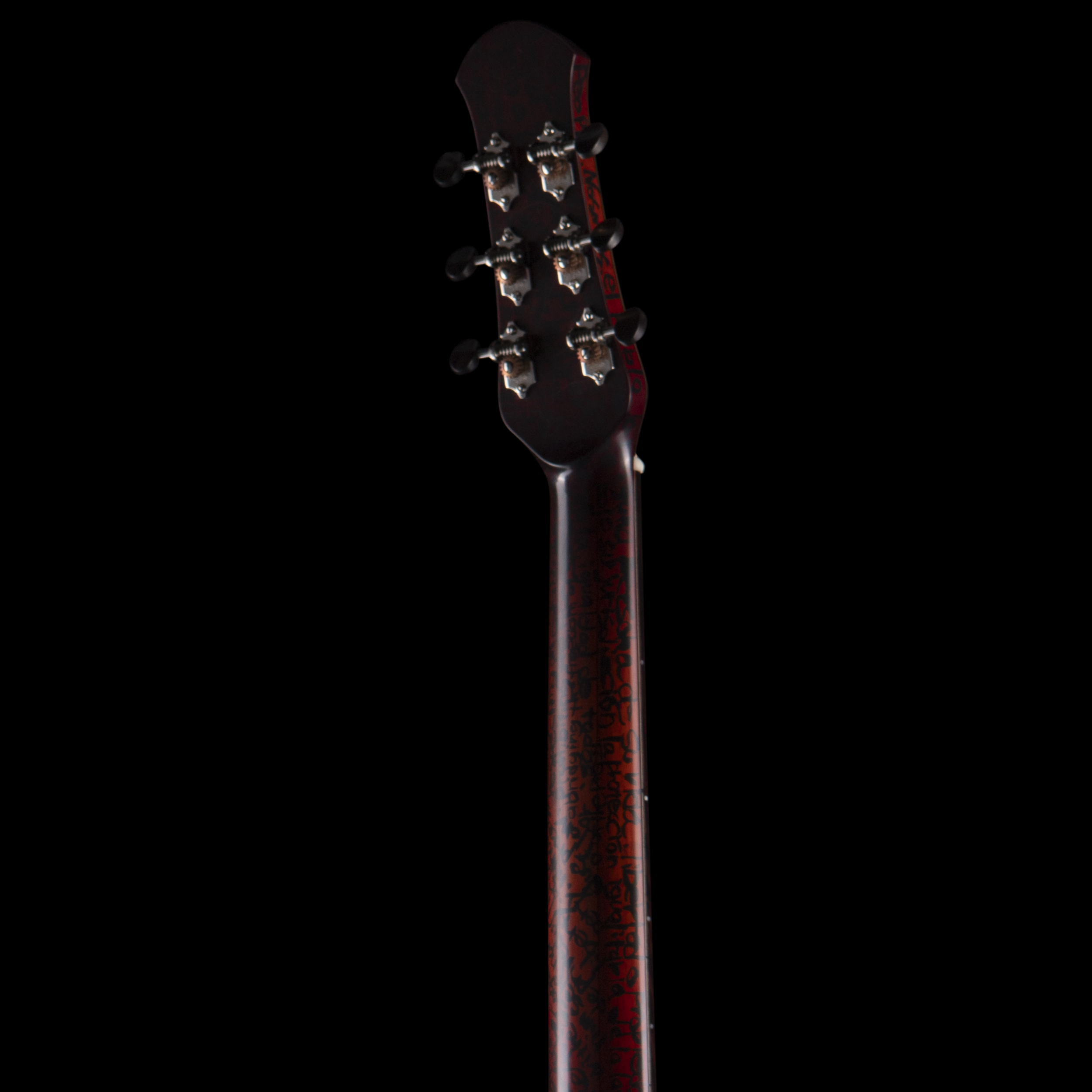 Close-up view of a Matsuda guitar headstock showing tuning pegs and the neck with red branding, against a black background.