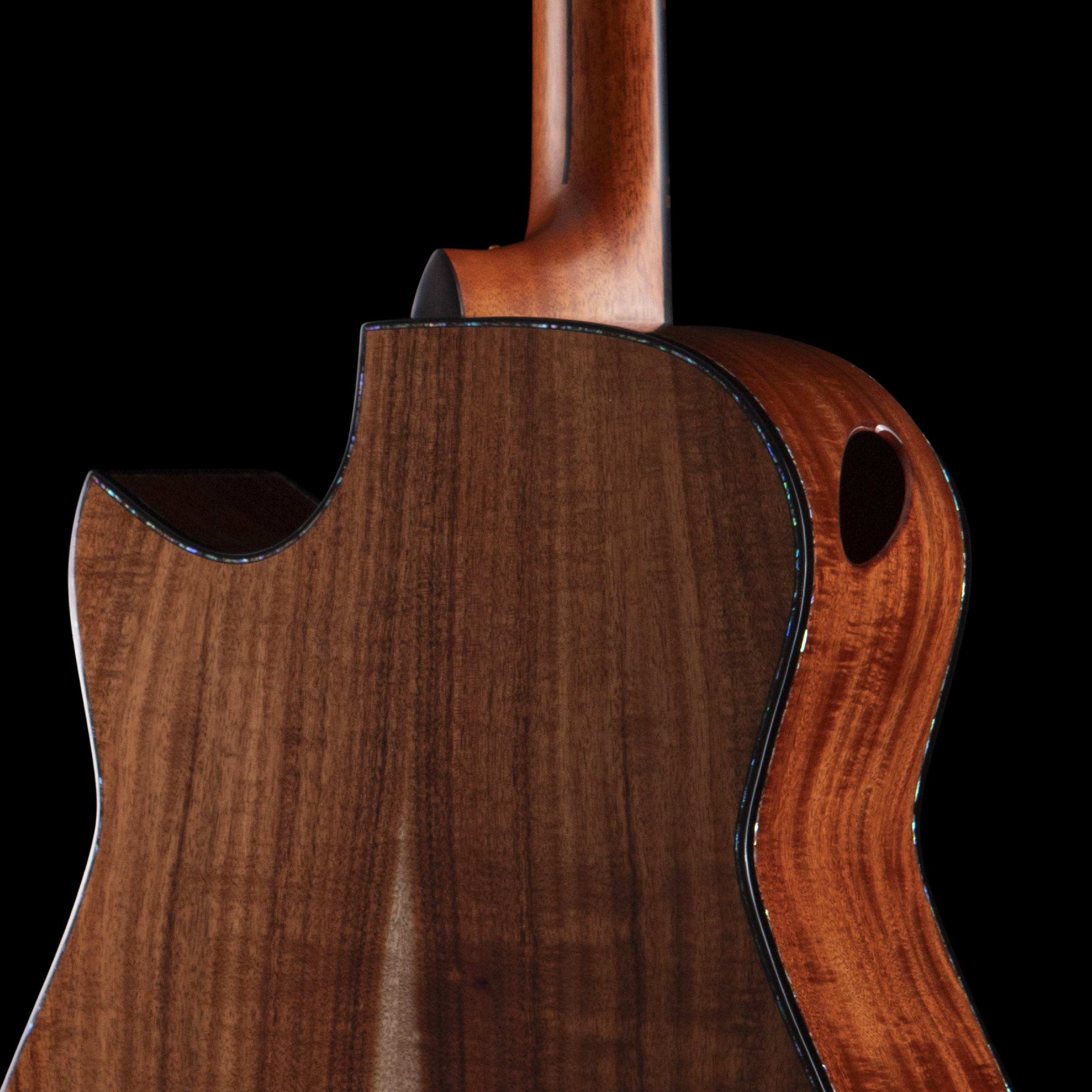 Close-up of the side of an acoustic guitar with a glossy wooden finish, set against a black background.