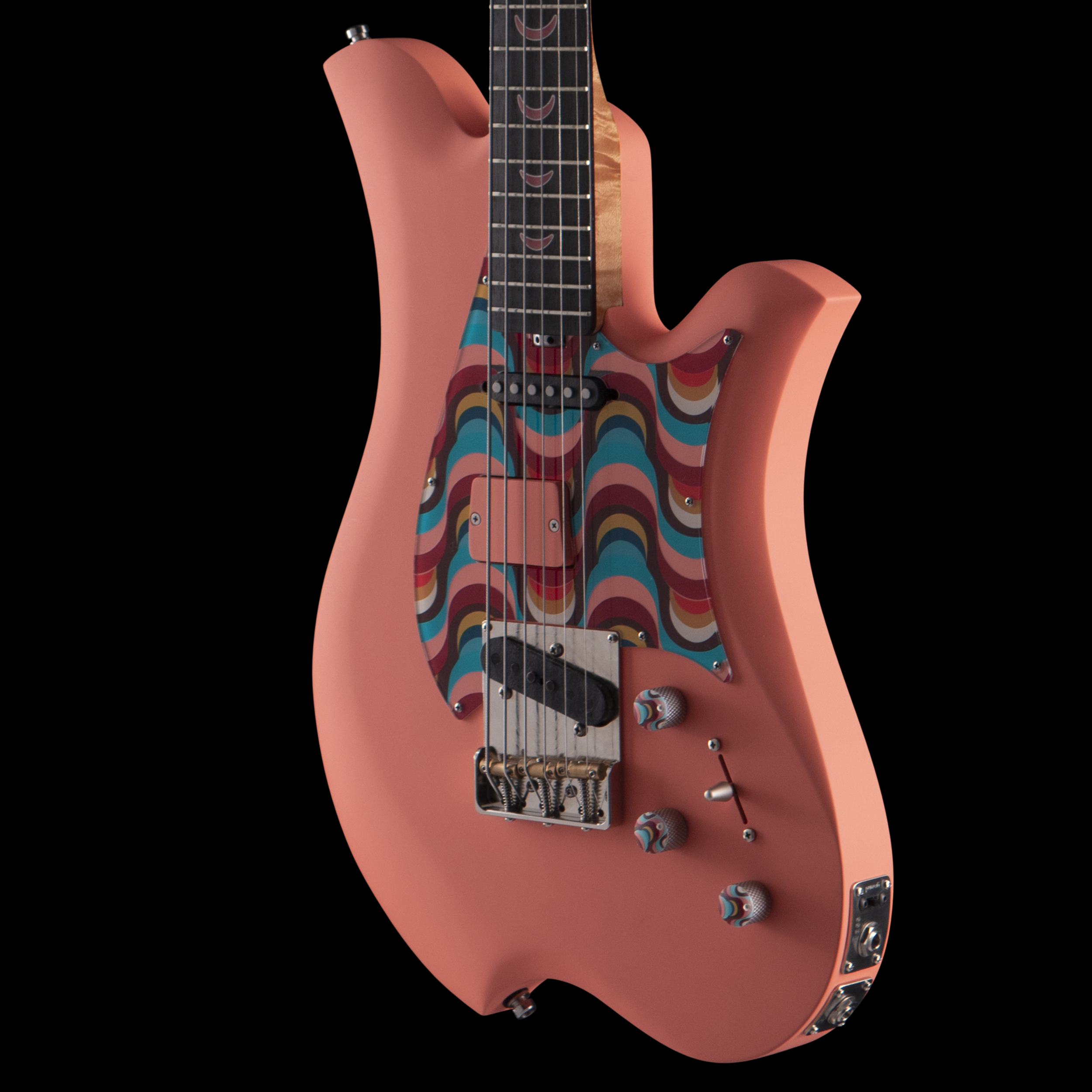 A pink electric Bacci guitar with colorful swirl pattern and smiley face stickers on the fretboard, set against a black background.