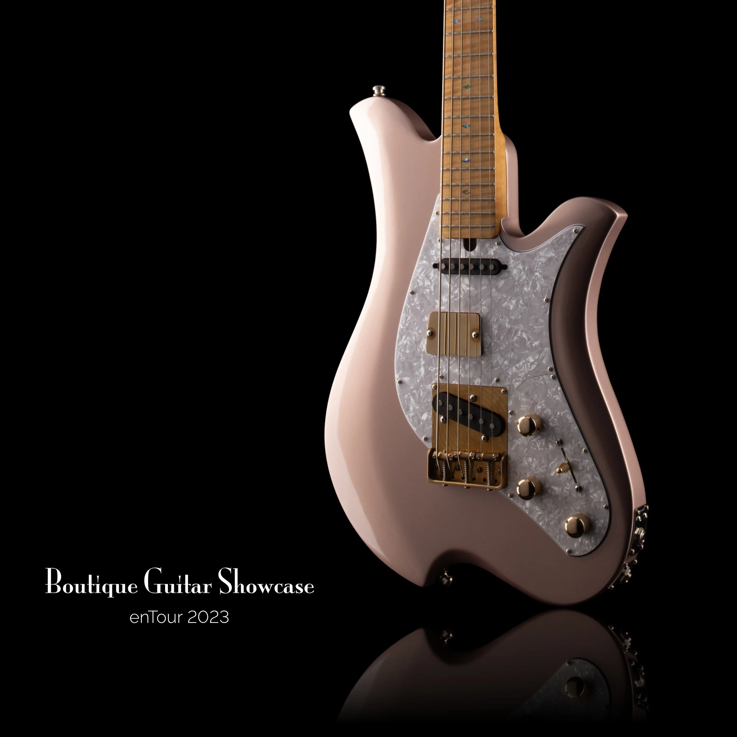 Bacci Baritone electric guitar with unique design, metallic finish, pearl pickguard, and gold hardware; text "Boutique Guitar Showcase enTour 2023" on black background.