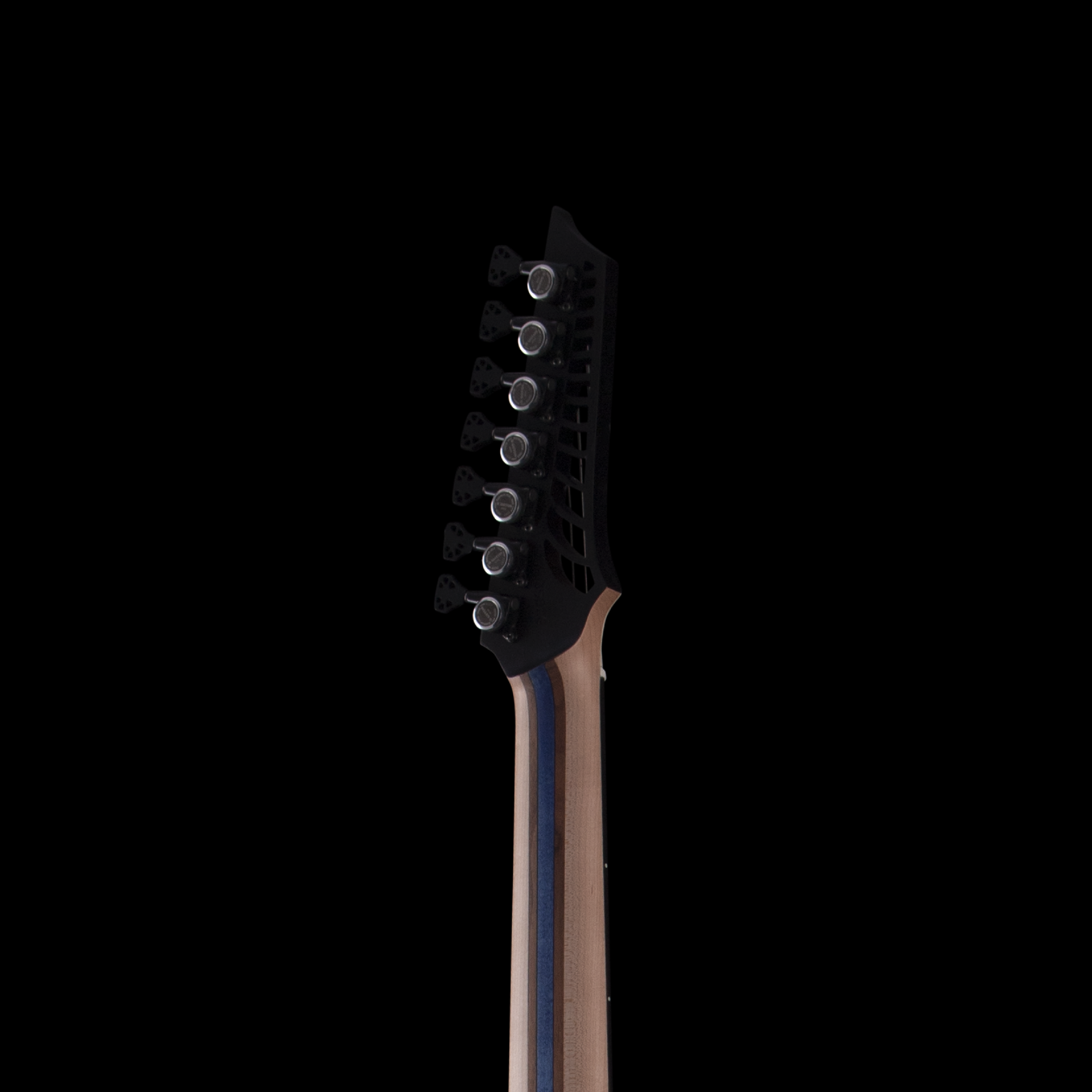 Close-up of the headstock of a black electric OD guitar, showing tuning pegs and strings against a black background.
