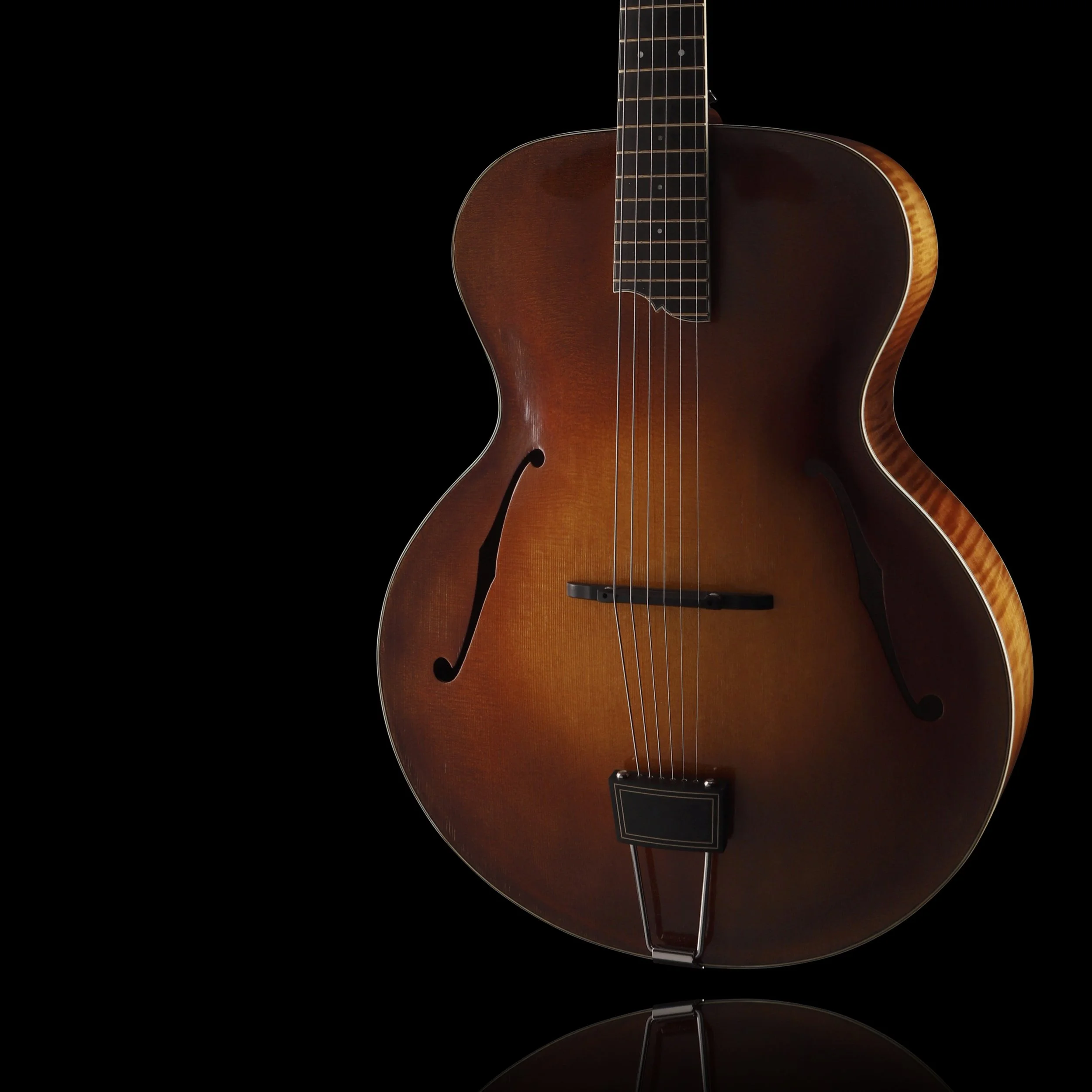 A vintage brown hollow-body electric Cedar Mountain guitar with F-shaped sound holes, set against a black background.