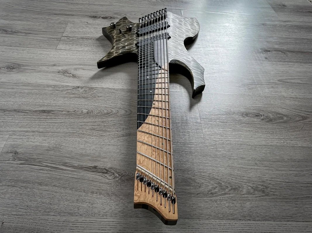 Extended-range GNG Giulio Negrini electric guitar with multiple strings on a wooden floor.