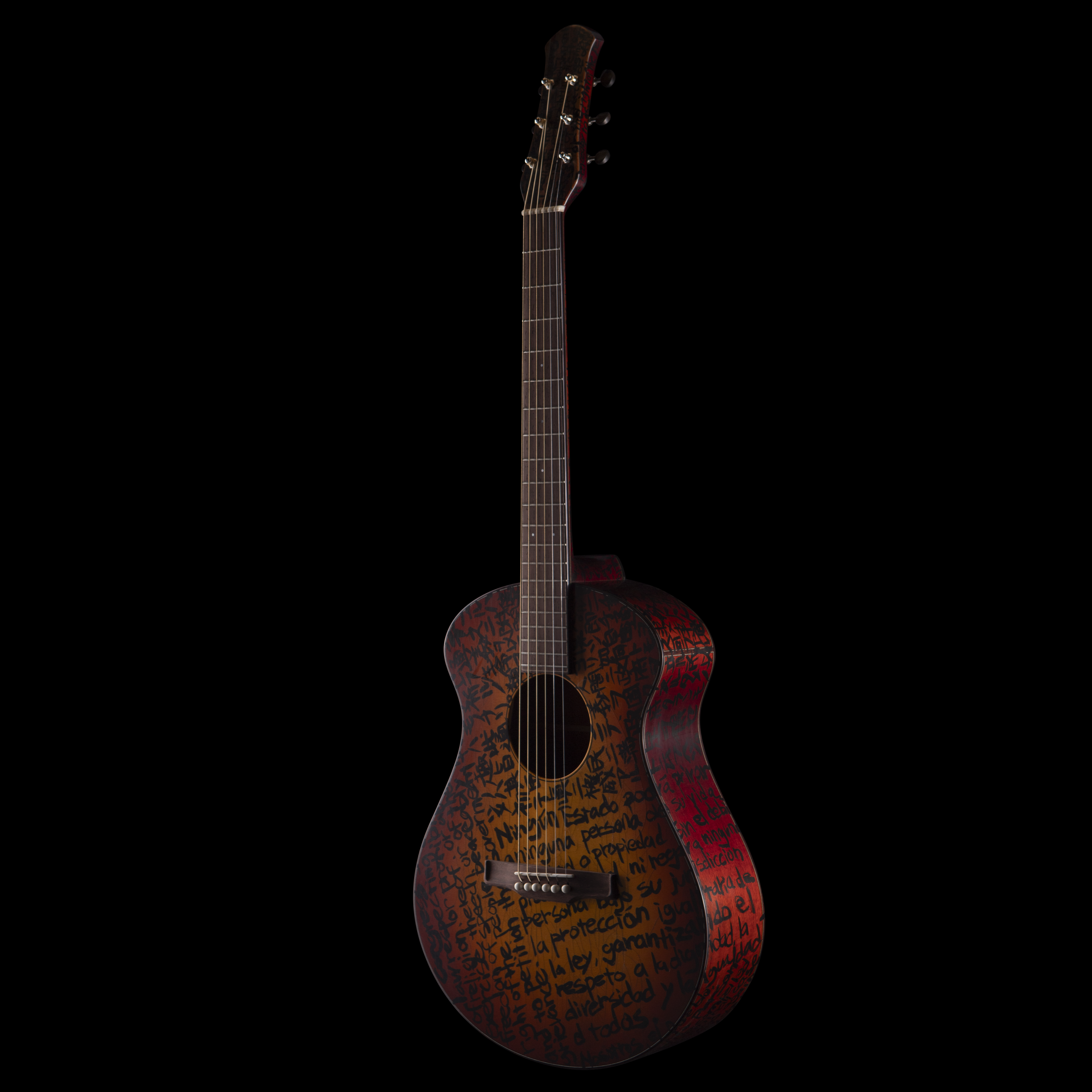 A Matsuda acoustic guitar with a black background and red and black graffiti-like writing on the body.