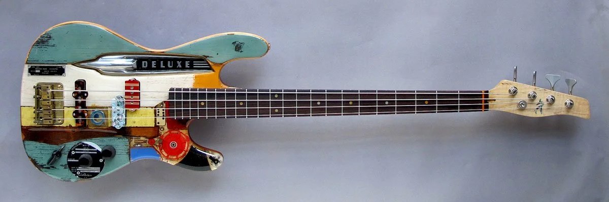 A colorful electric Spalt guitar with a distressed finish and various artistic details.