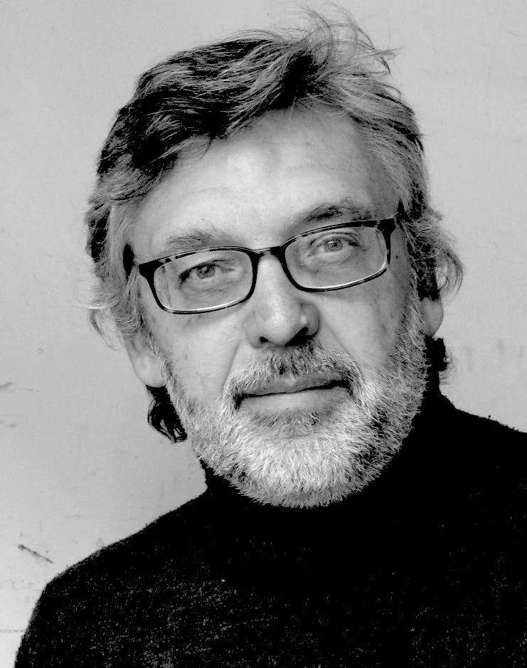 Black and white portrait of Michael Spalt with glasses, gray hair, and a beard, wearing a dark turtleneck.
