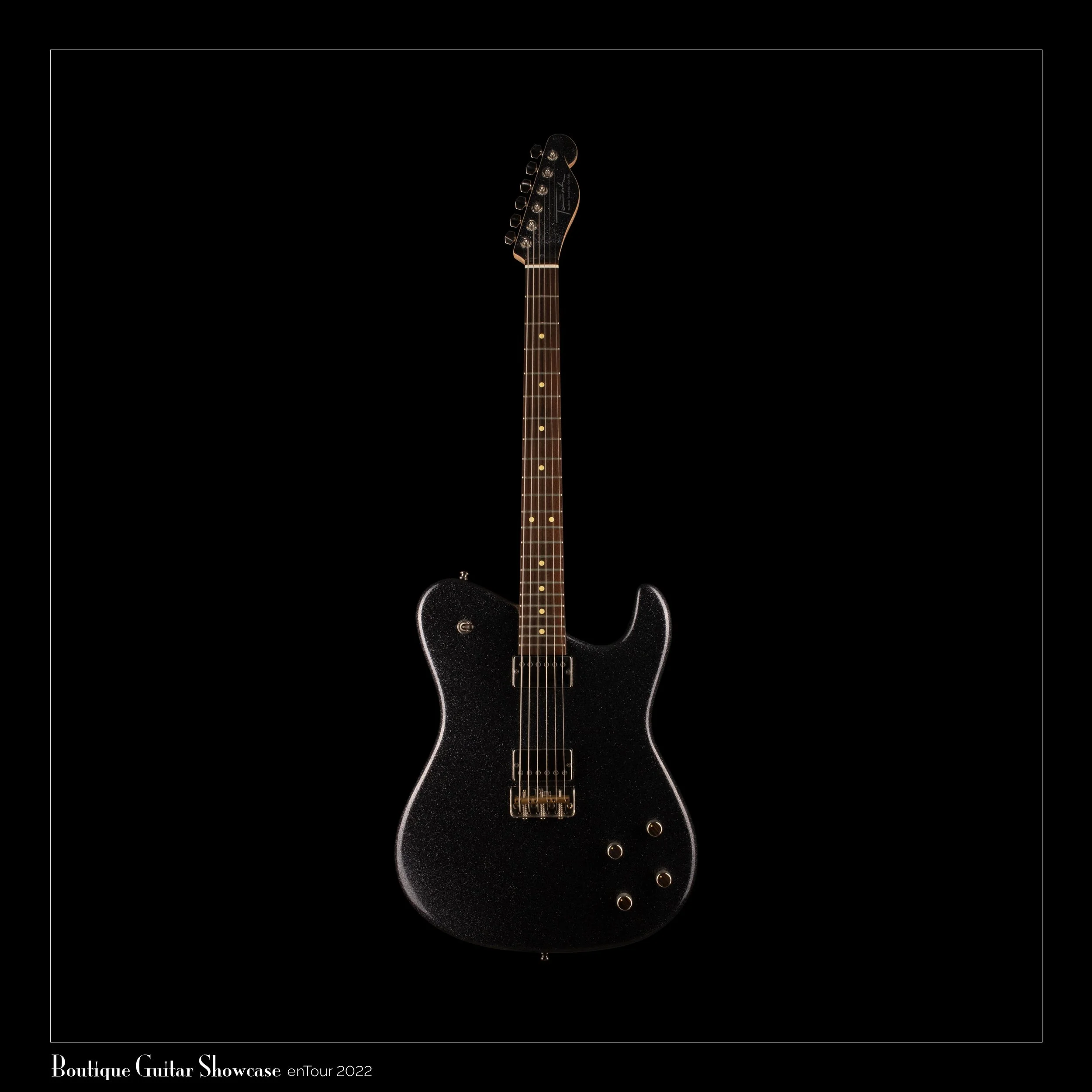 Black Tausch electric guitar with a textured finish hanging against a black background, labelled as part of a 2022 boutique guitar showcase collection.