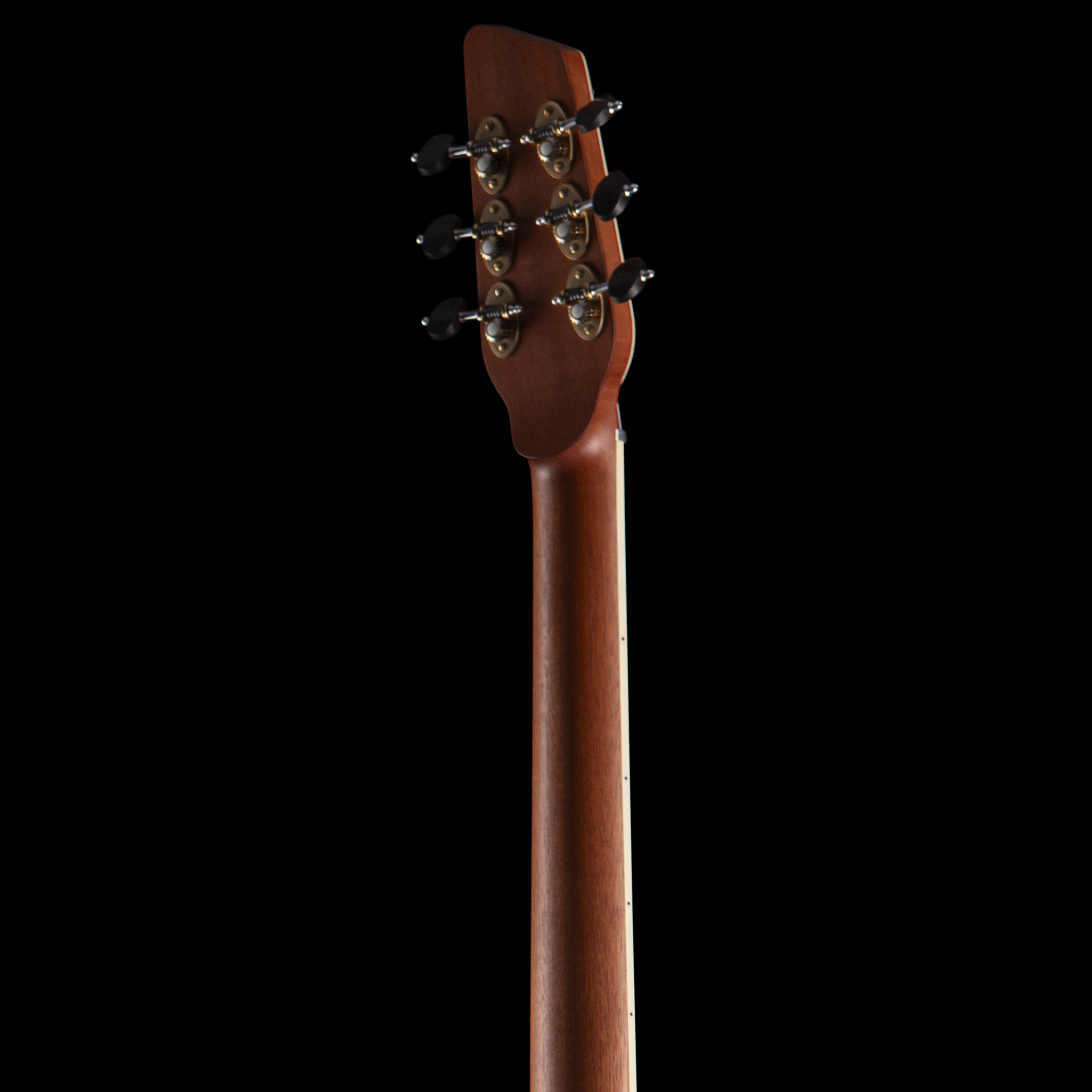 Close-up of the headstock of a wooden Island Instrument acoustic guitar showing tuning pegs against a black background.