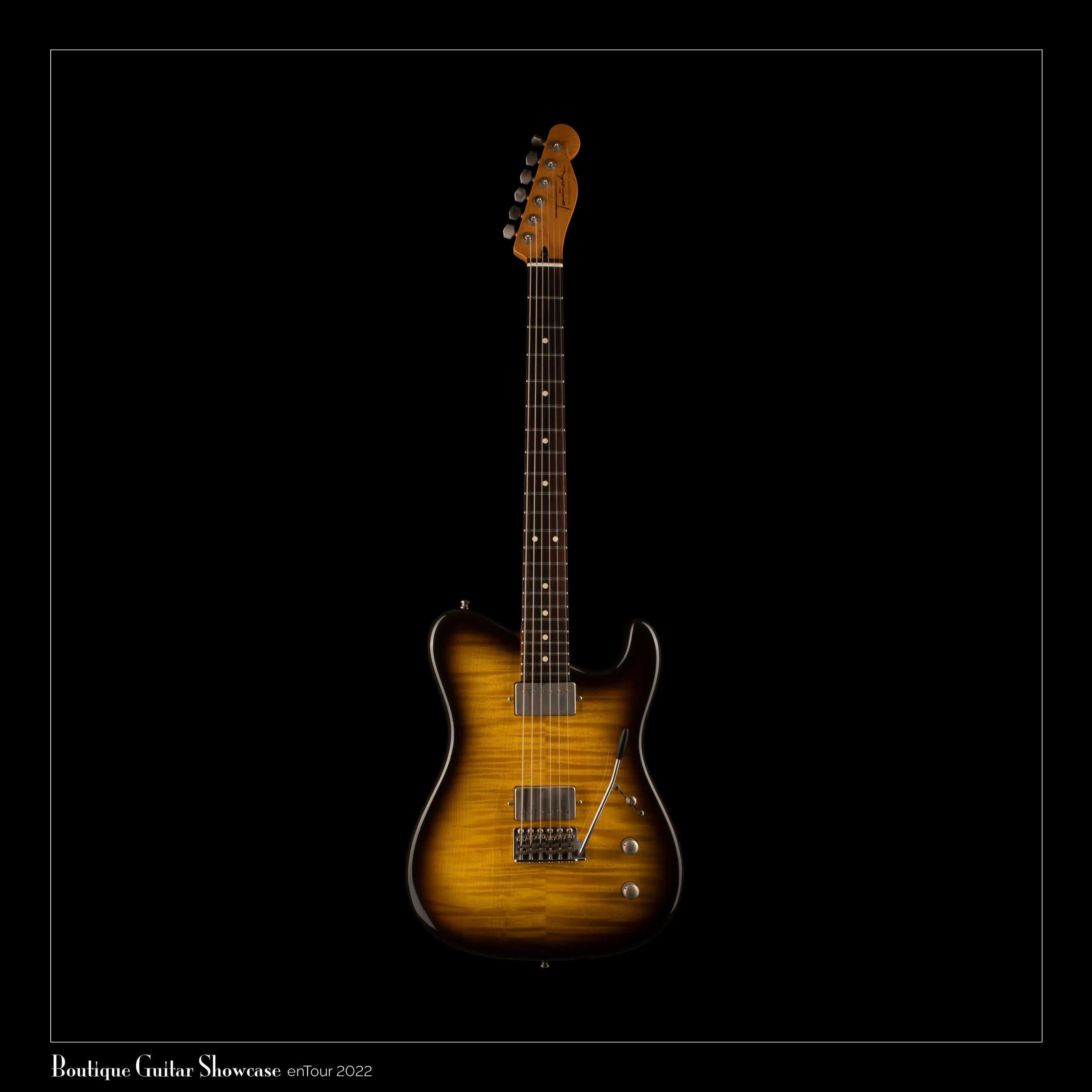 Sunburst Tausch electric guitar with a sleek body and a vintage-style tremolo bridge.