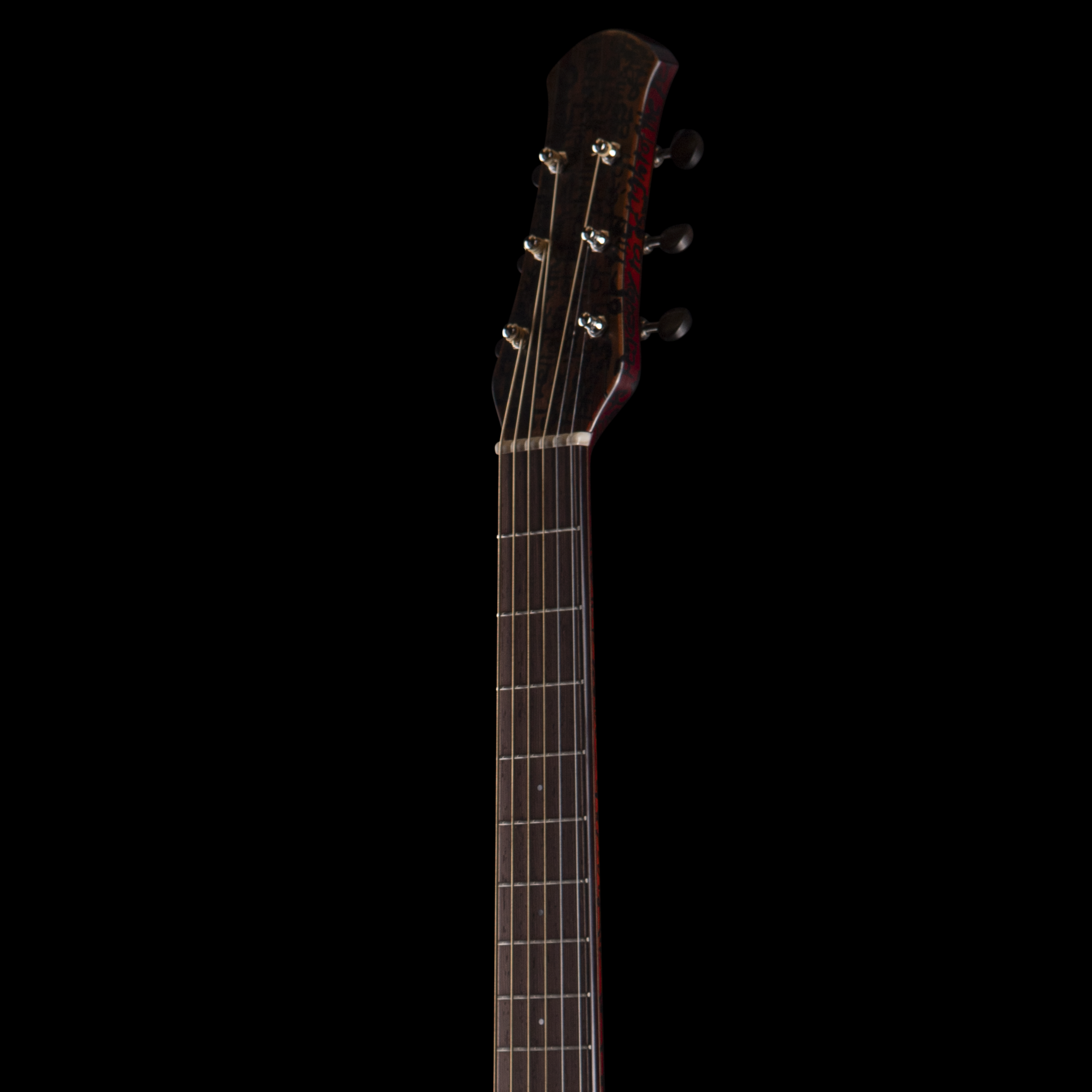 Close-up of the dark wooden headstock of a Matsuda guitar with tuning pegs against a black background.