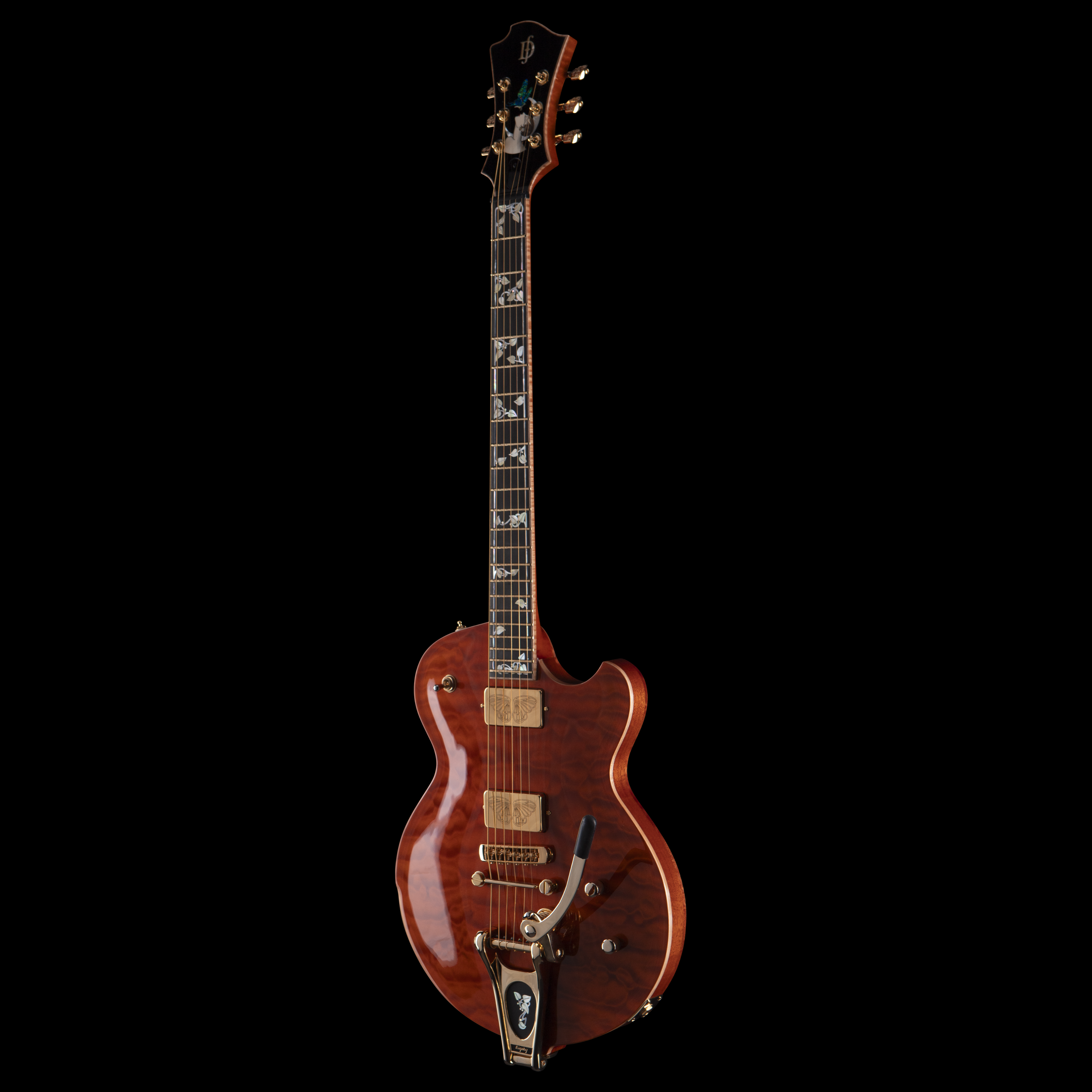 A vintage brown electric Djerjinski guitar with ornate inlay on the fretboard, positioned vertically against a black background.