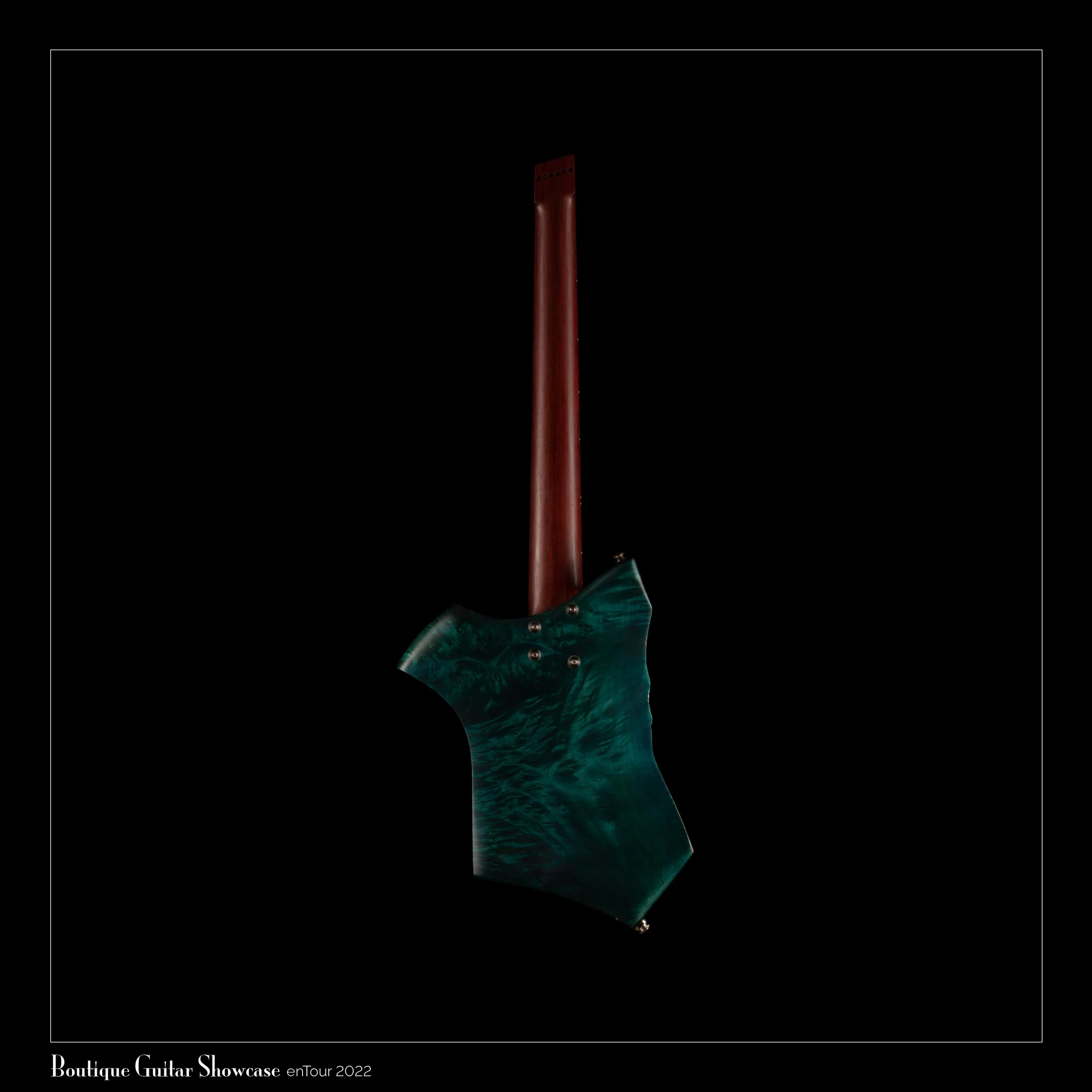 Back view of a uniquely shaped guitar with a wooden neck and a blue-green body, displayed against a black background.